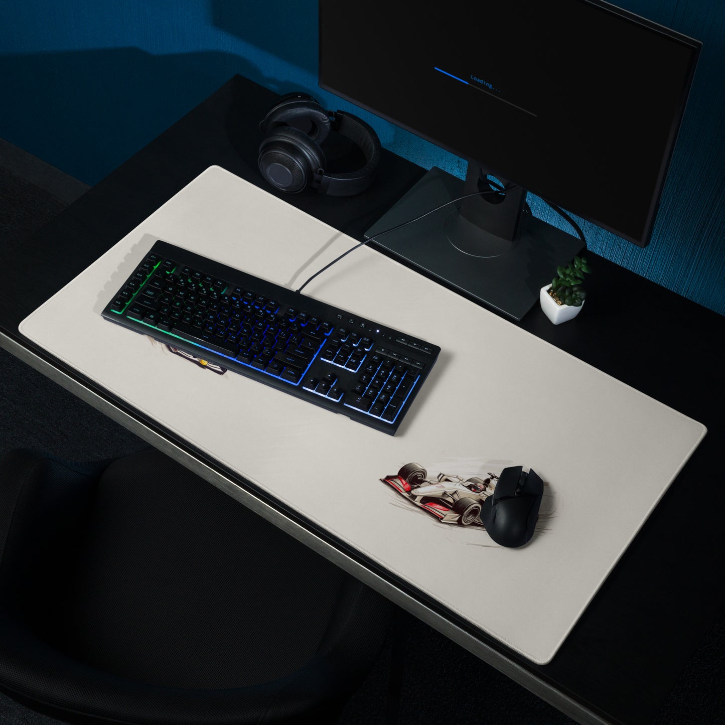 A 36" x 18" desk pad with two fast formula one cars on the sides shown on a desk setup. Beige in color.