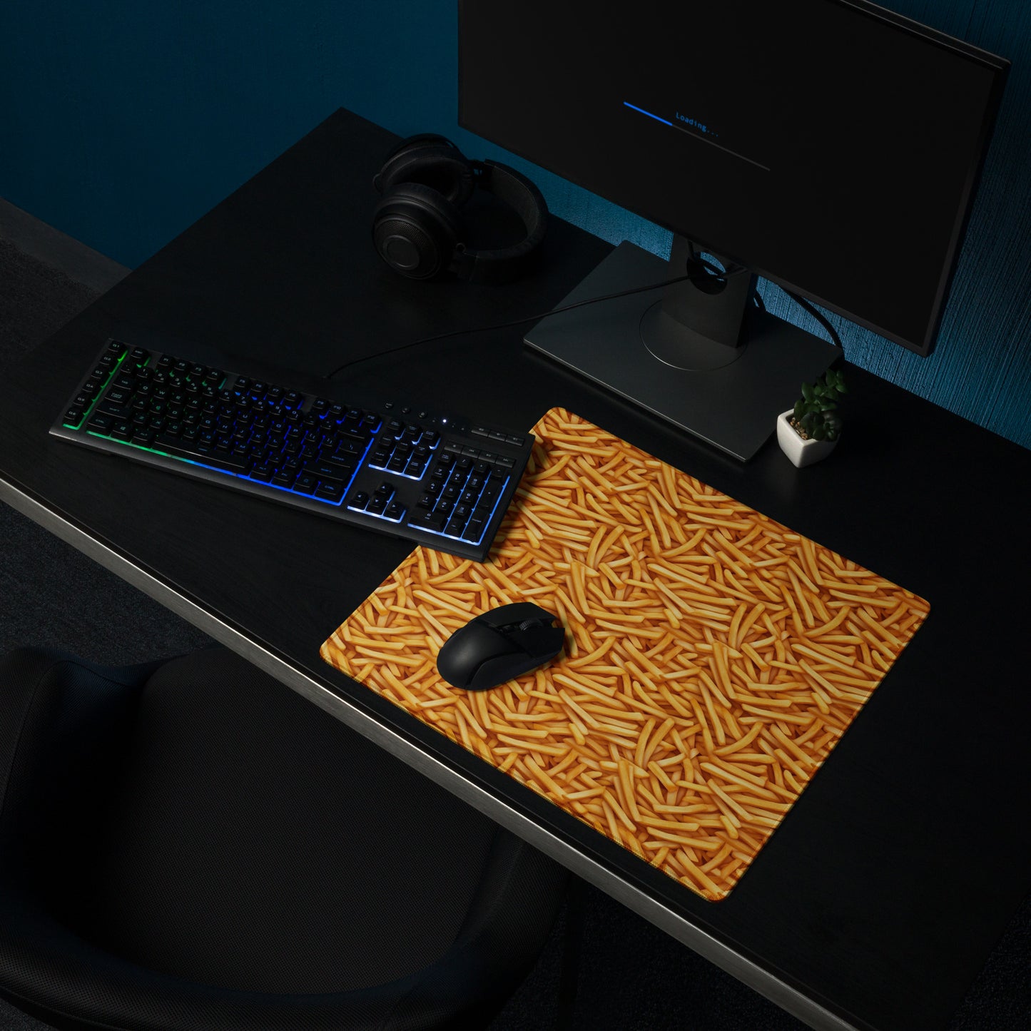 A 18" x 16" desk pad with a bunch of french fries all over it shown on a desk setup. Yellow in color.