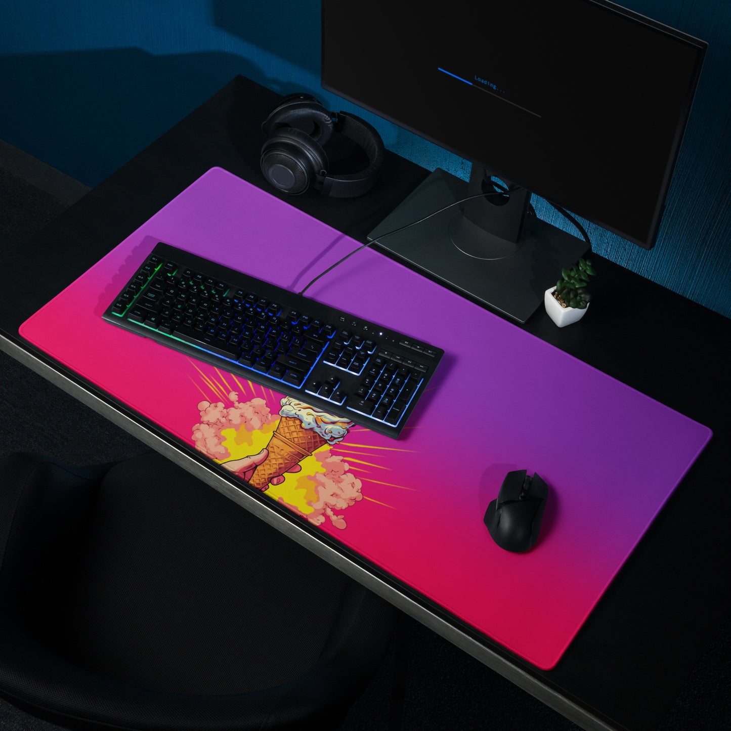 A 36" x 18" desk pad with a brightly colored ice cream cone in the middle of it shown on a desk setup. Pink and purple in color.