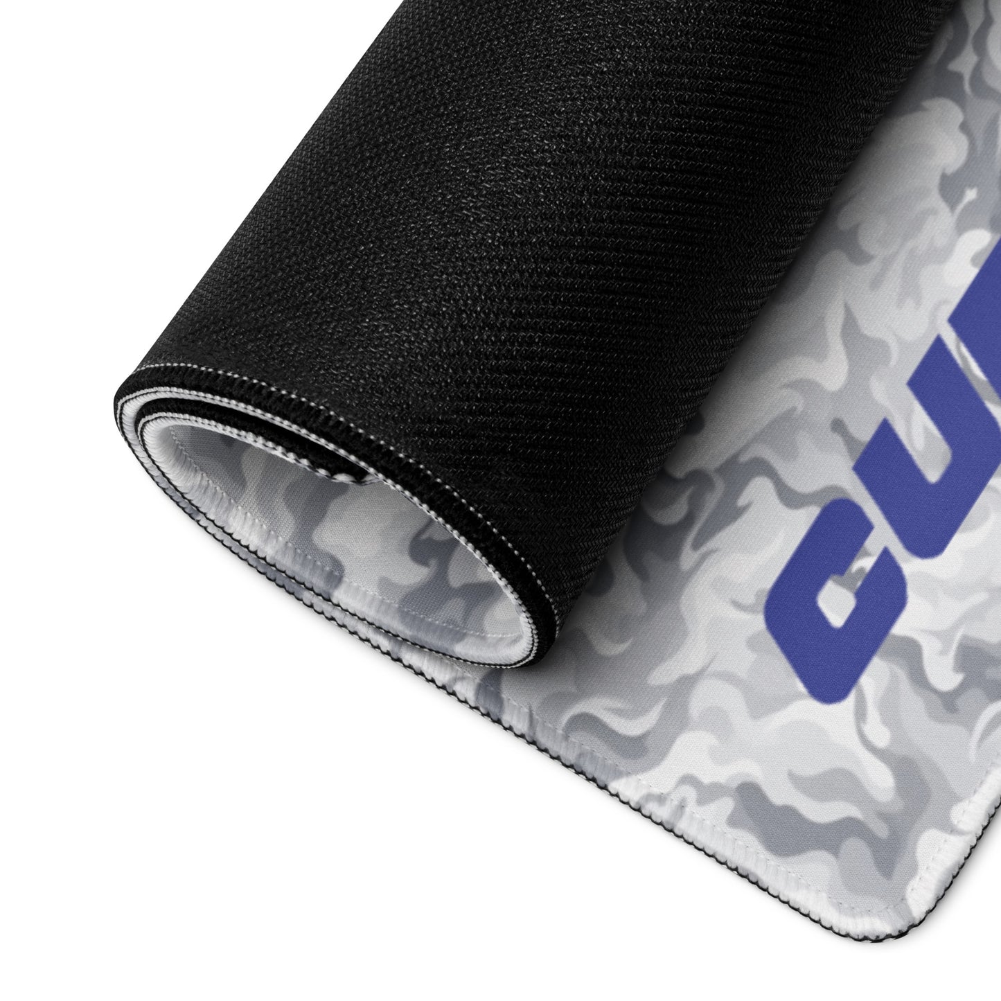 A 36" x 18" desk pad with a camo pattern and the word "Cup Rubber" on it in the bottom left corner rolled up. Beige and White in color.