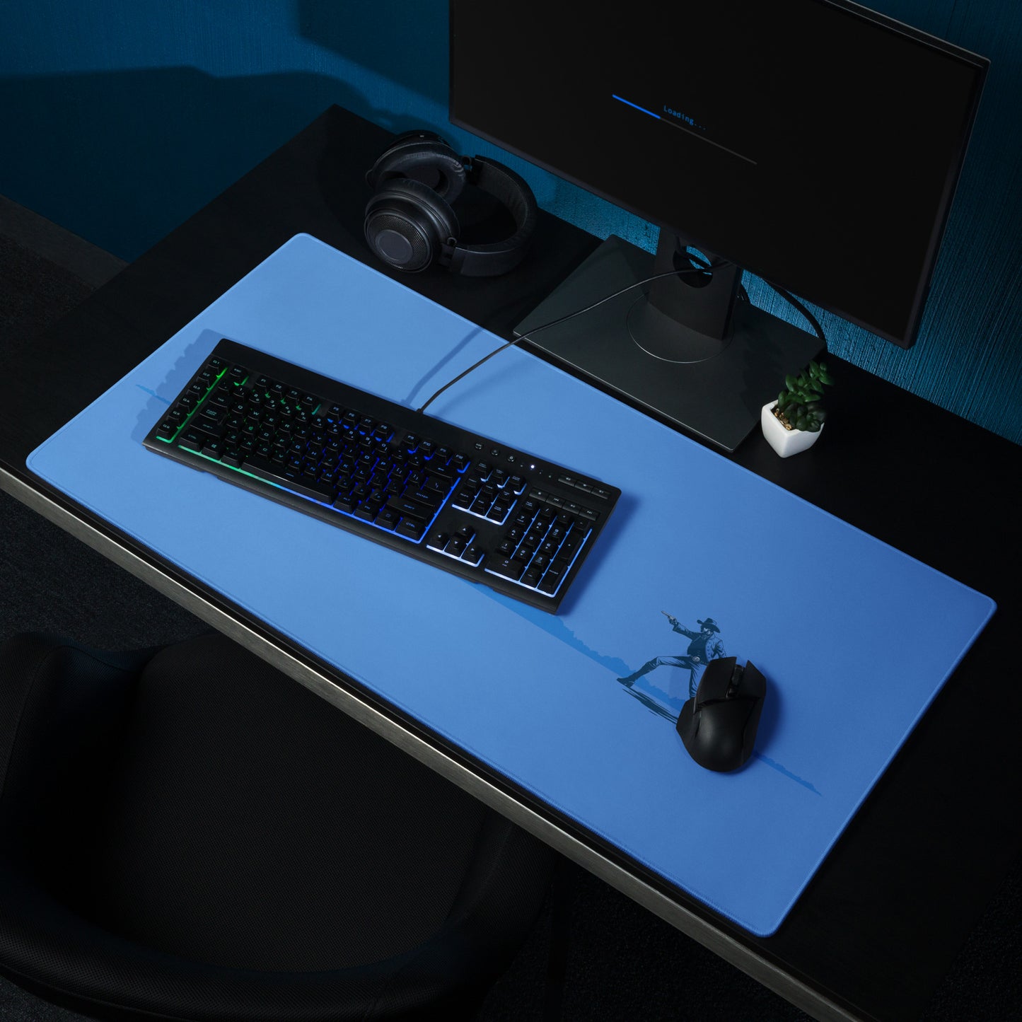 A blue 36" x 18" desk pad with two cowboys dueling sitting on a desk.