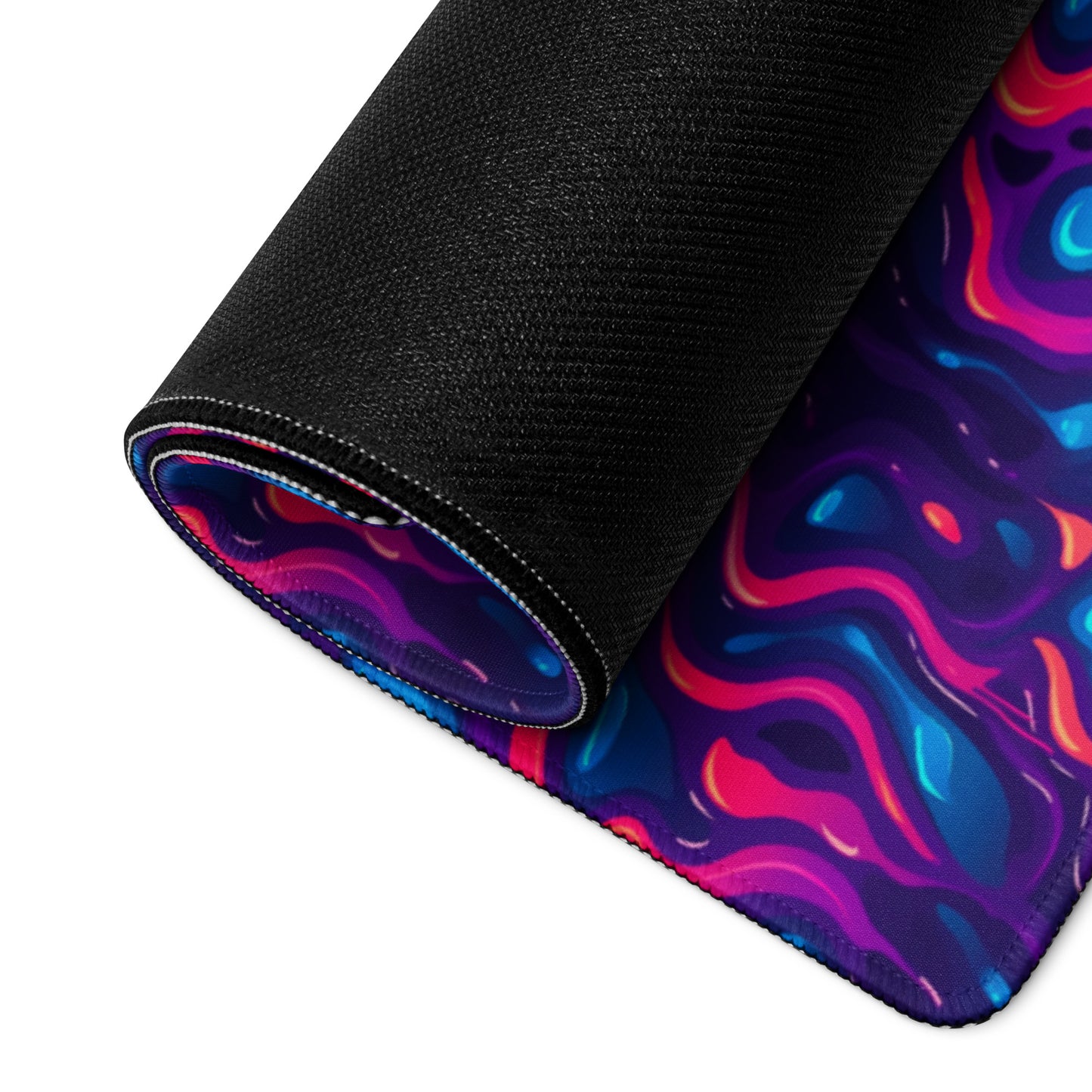A 36" x 18" desk pad with a pink, blue and purple wavy pattern rolled up.
