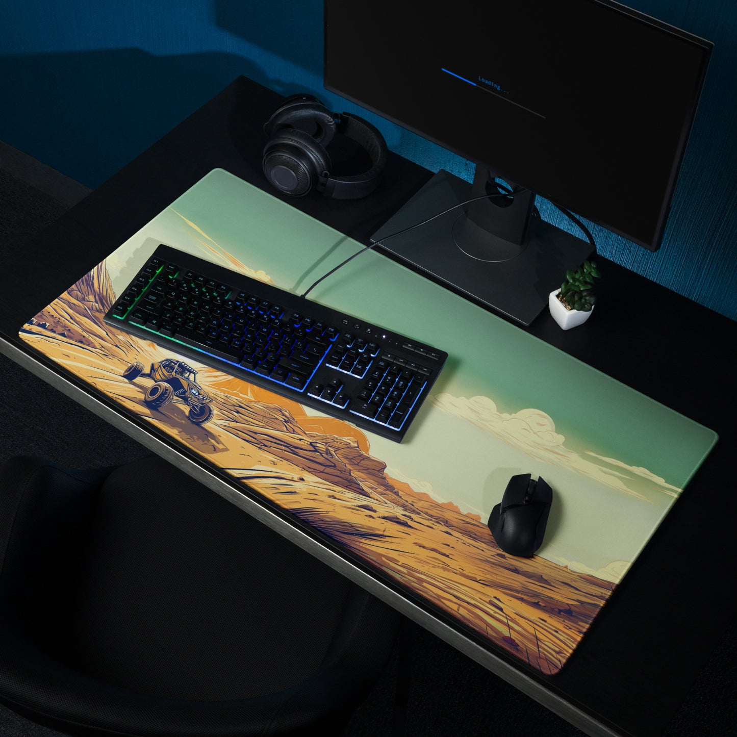 A 36" x 18" desk pad with a dune buggy in a desert landscape sitting on a desk.