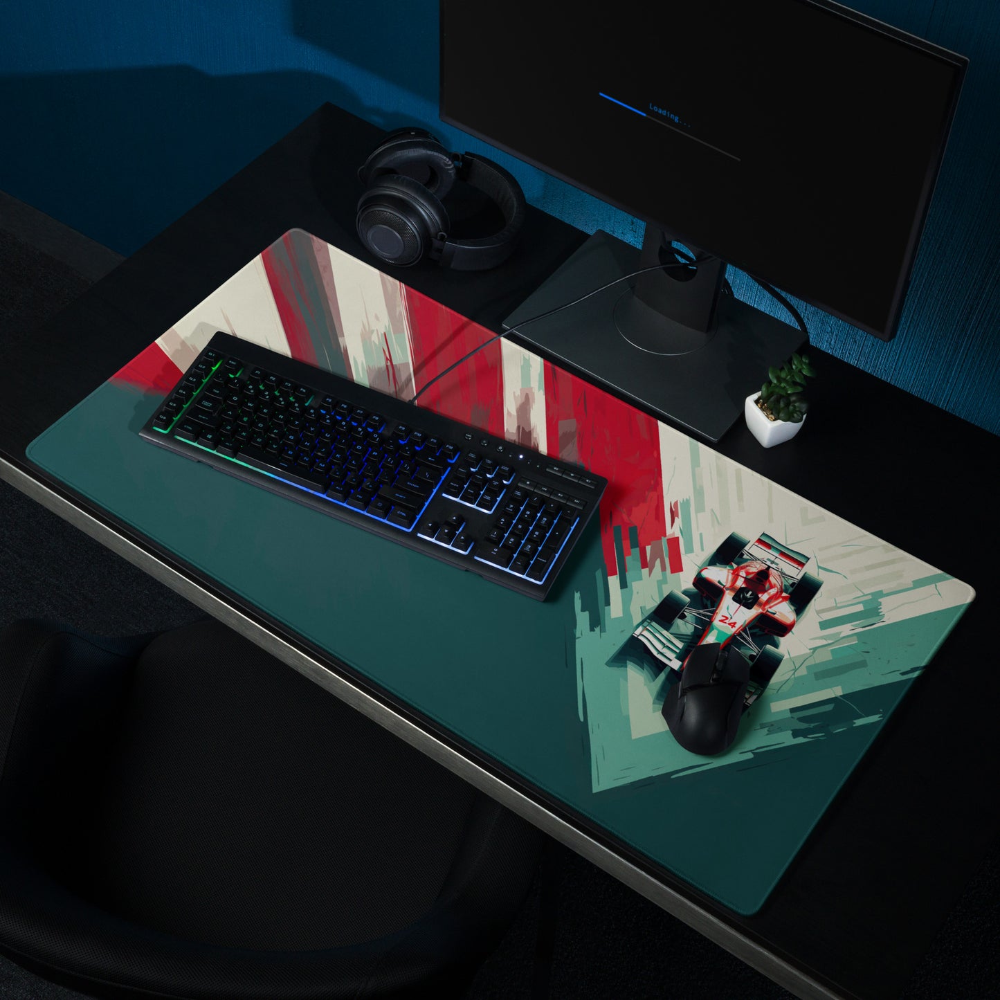 A 36" x 18" teal, red, and white desk pad with a formula one car on the right sitting on a desk.