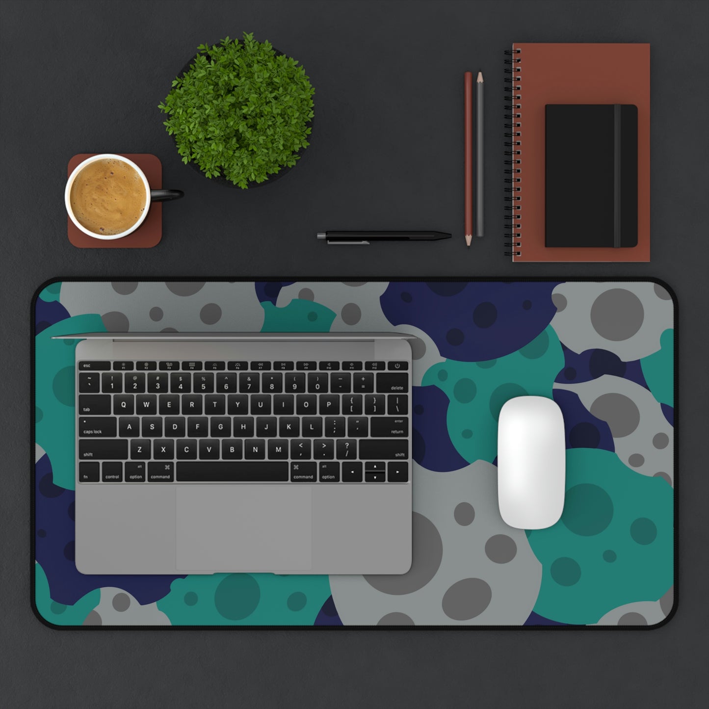 A 12" x 22" desk mat with gray, teal, and dark blue meteorites. A laptop and mouse sit on top of it.
