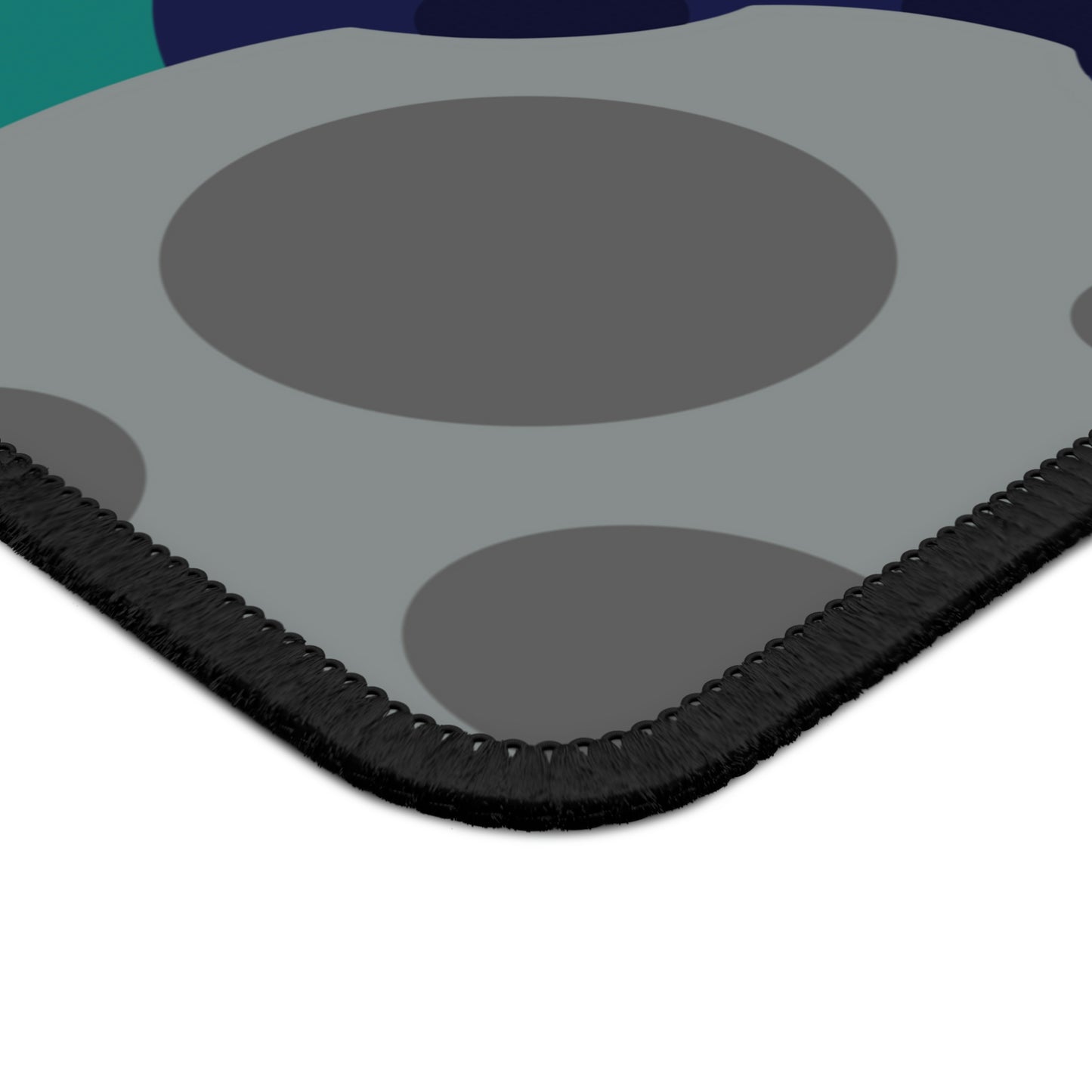 The corner of a gaming mouse pad with gray, teal, and dark blue meteorites.