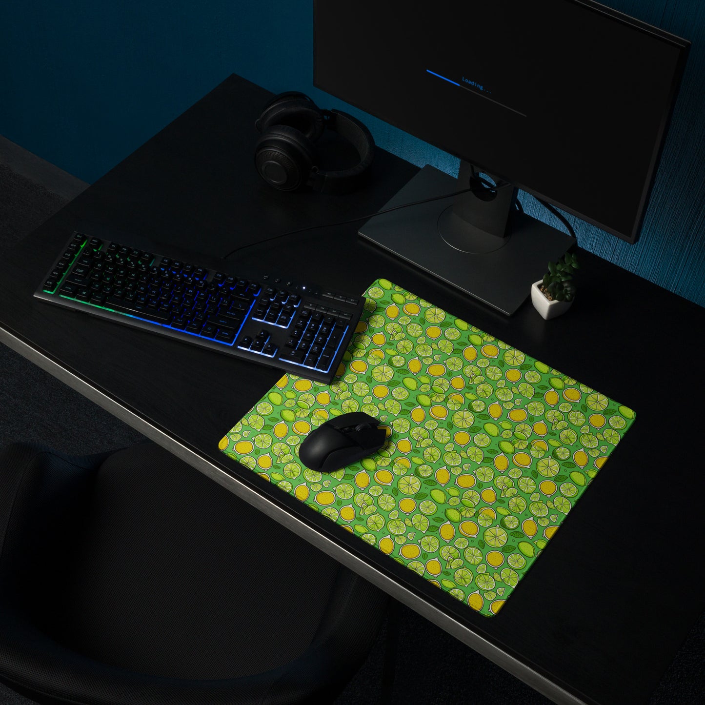 An 18" x 16" gaming desk pad with lemons and limes on a green background. A keyboard and mouse sit on it.
