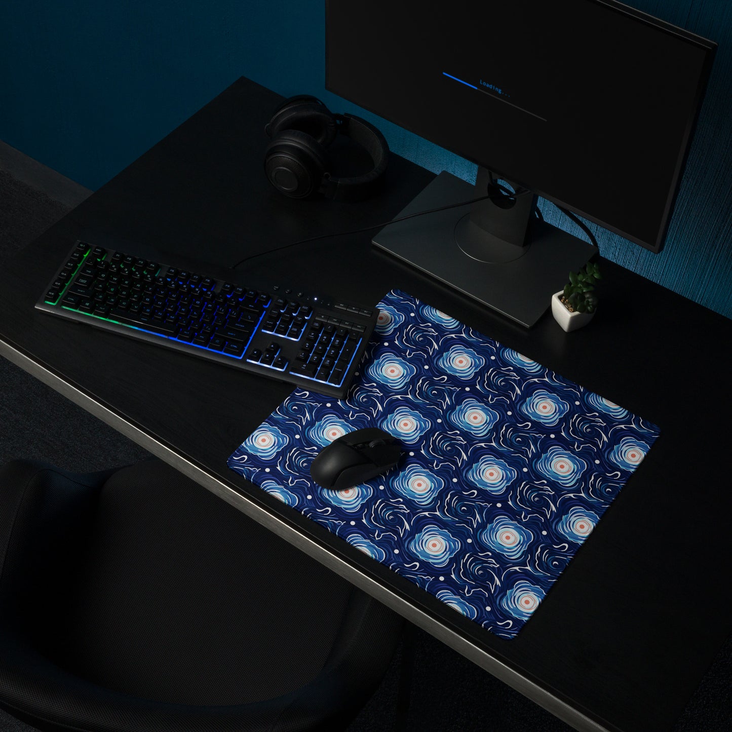 A 18" x 16" desk pad with a blue and white floral pattern sitting on a desk.