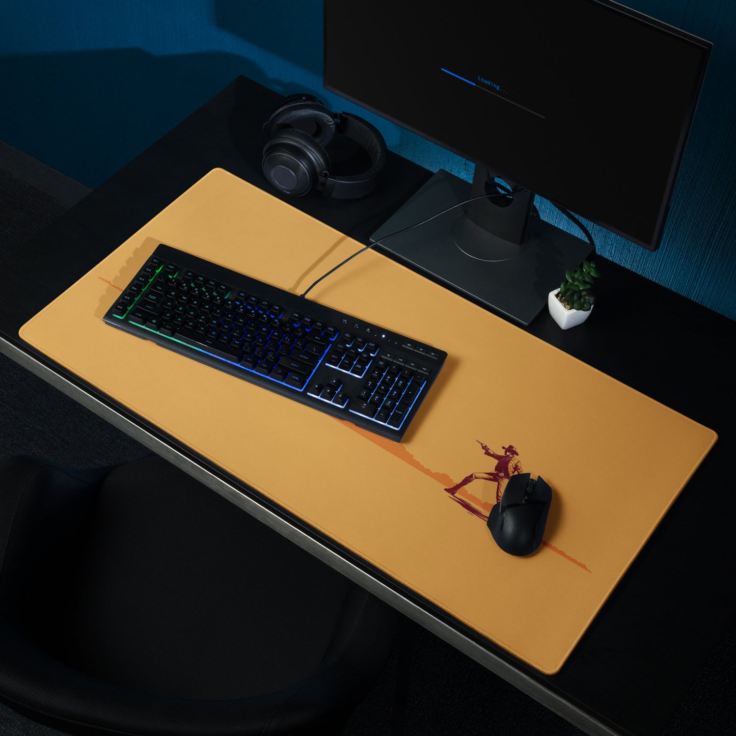 An orange 36" x 18" desk pad with cowboys dueling sitting on a desk.
