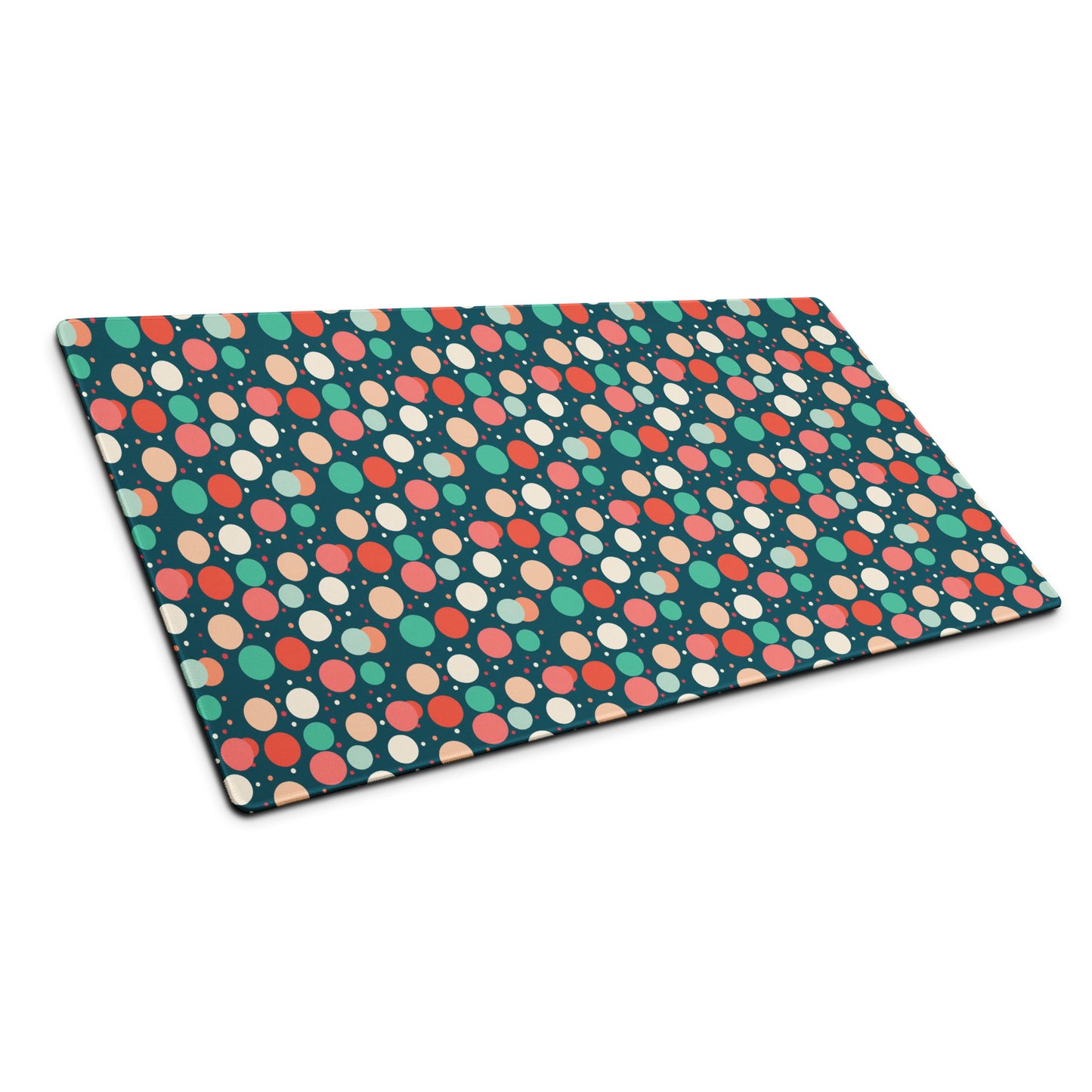 A 36" x 18" desk pad with red teal and yellow polka dot pattern sitting at an angle.