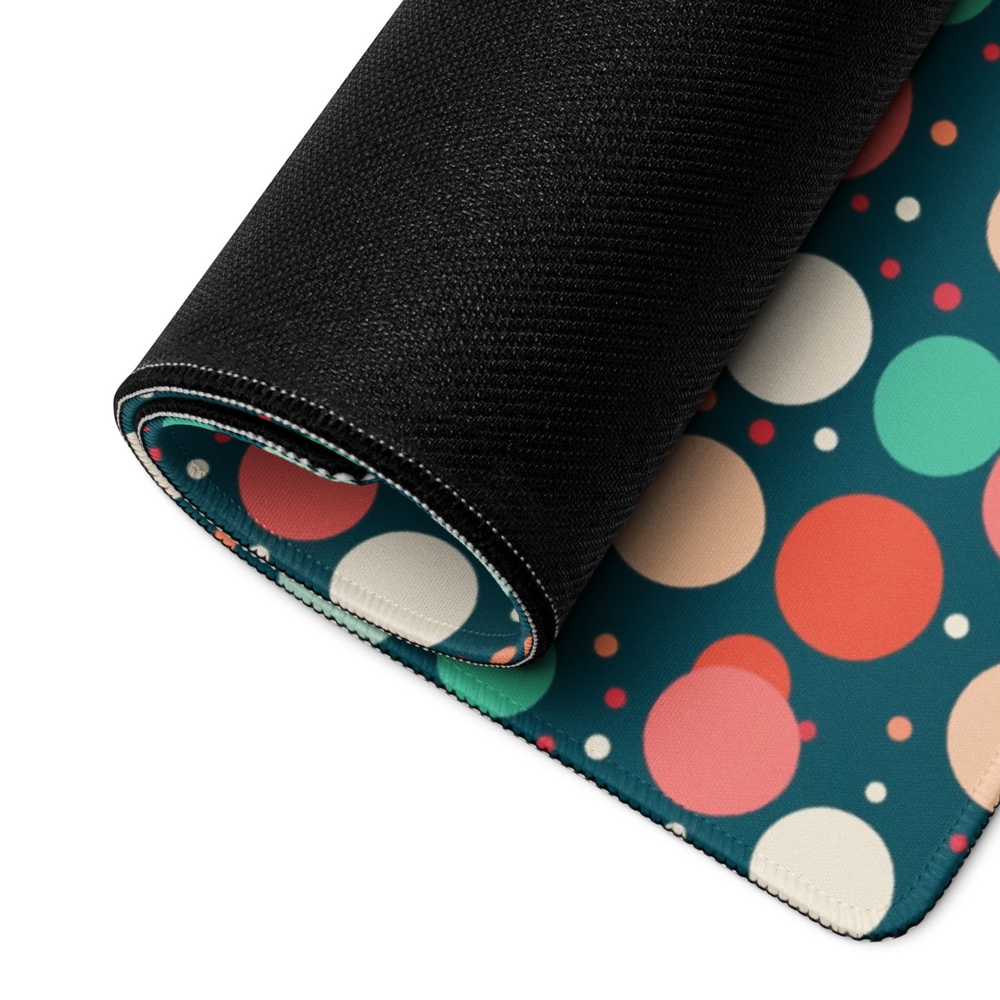 A 36" x 18" desk pad with red teal and yellow polka dot pattern rolled up.