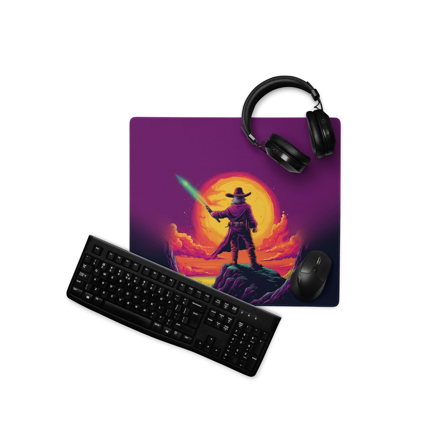 A 18" x 16" desk pad with a cowboy holding a glowing sword looking at the sunset. With a keyboard, mouse, and headphones sitting on it.