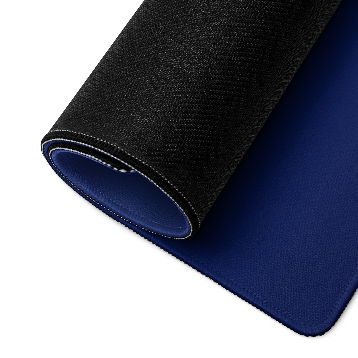 A 36" x 18" blue desk pad with three foxes in whirlpools rolled up.