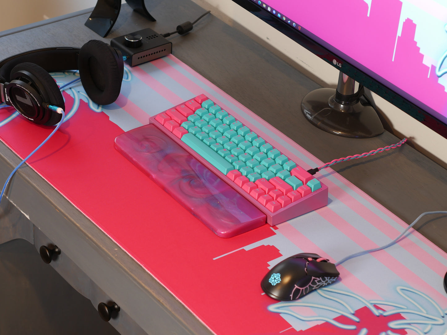Pink and blue Miami skyline desk mat sits on a wooden desk. Desk accessories sit on top.