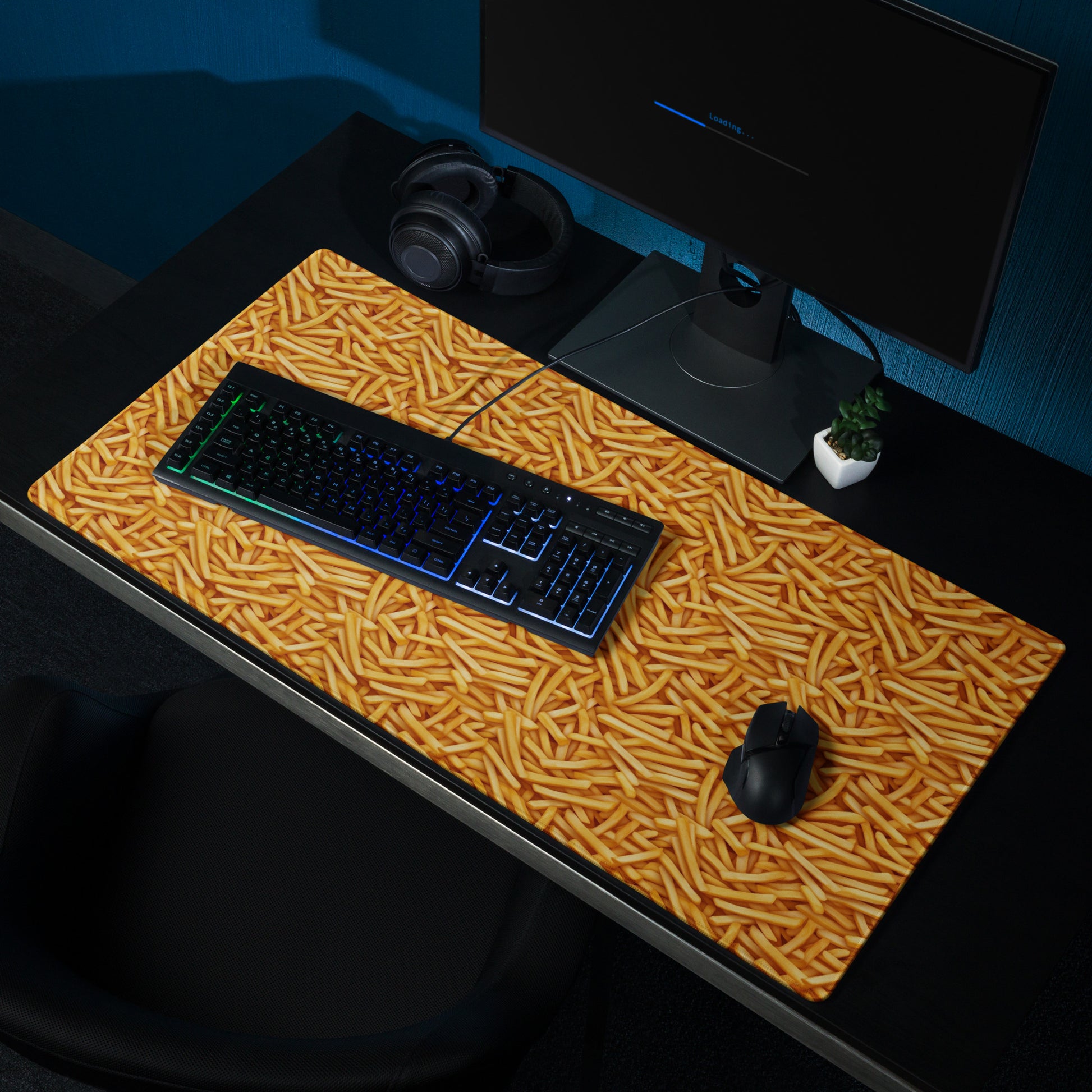 A 36" x 18" desk pad with a bunch of french fries all over it shown at a desk setup. Yellow in color.