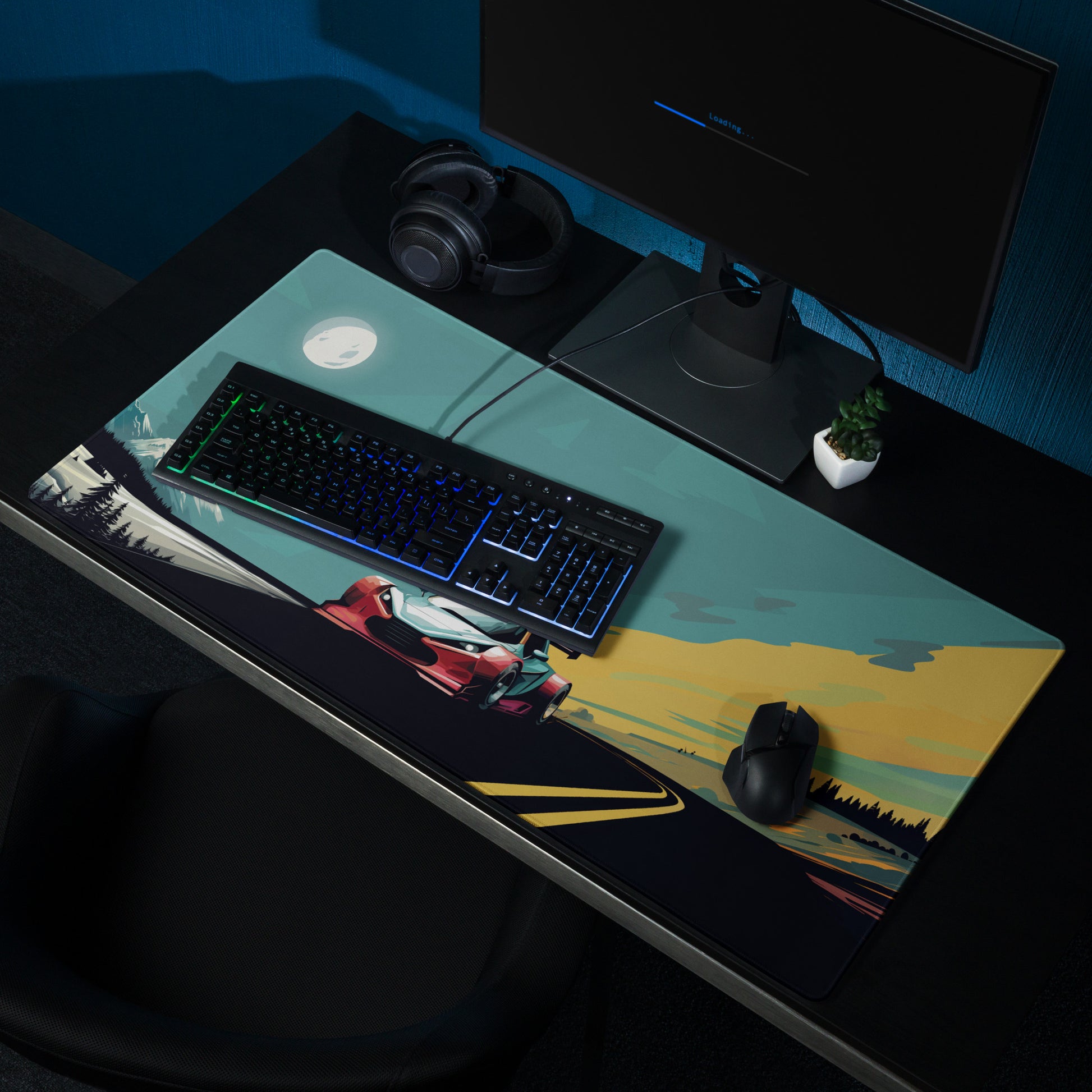 A 36" x 18" gaming desk pad with a futuristic GT car racing through the mountains shown on a desk setup. Blue and Grey in color.
