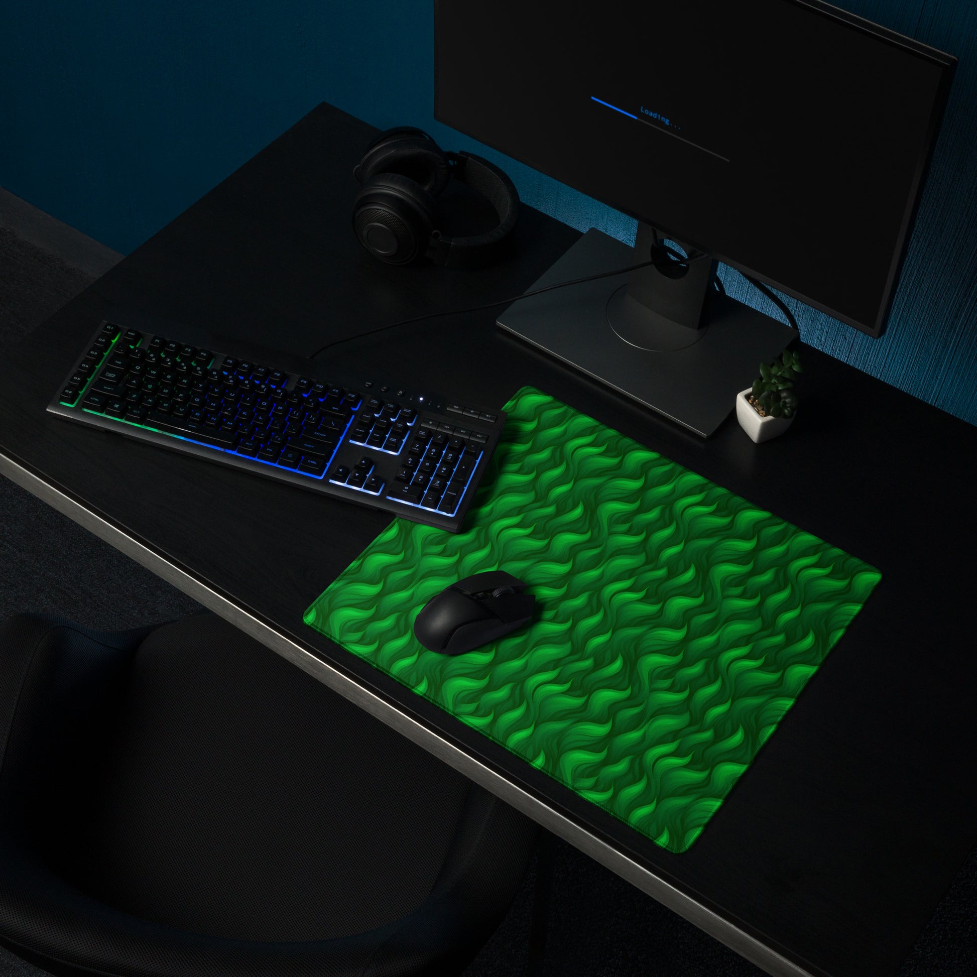 A 18" x 16" desk pad with a wavy flame pattern on it shown on a desk setup. Green in color.