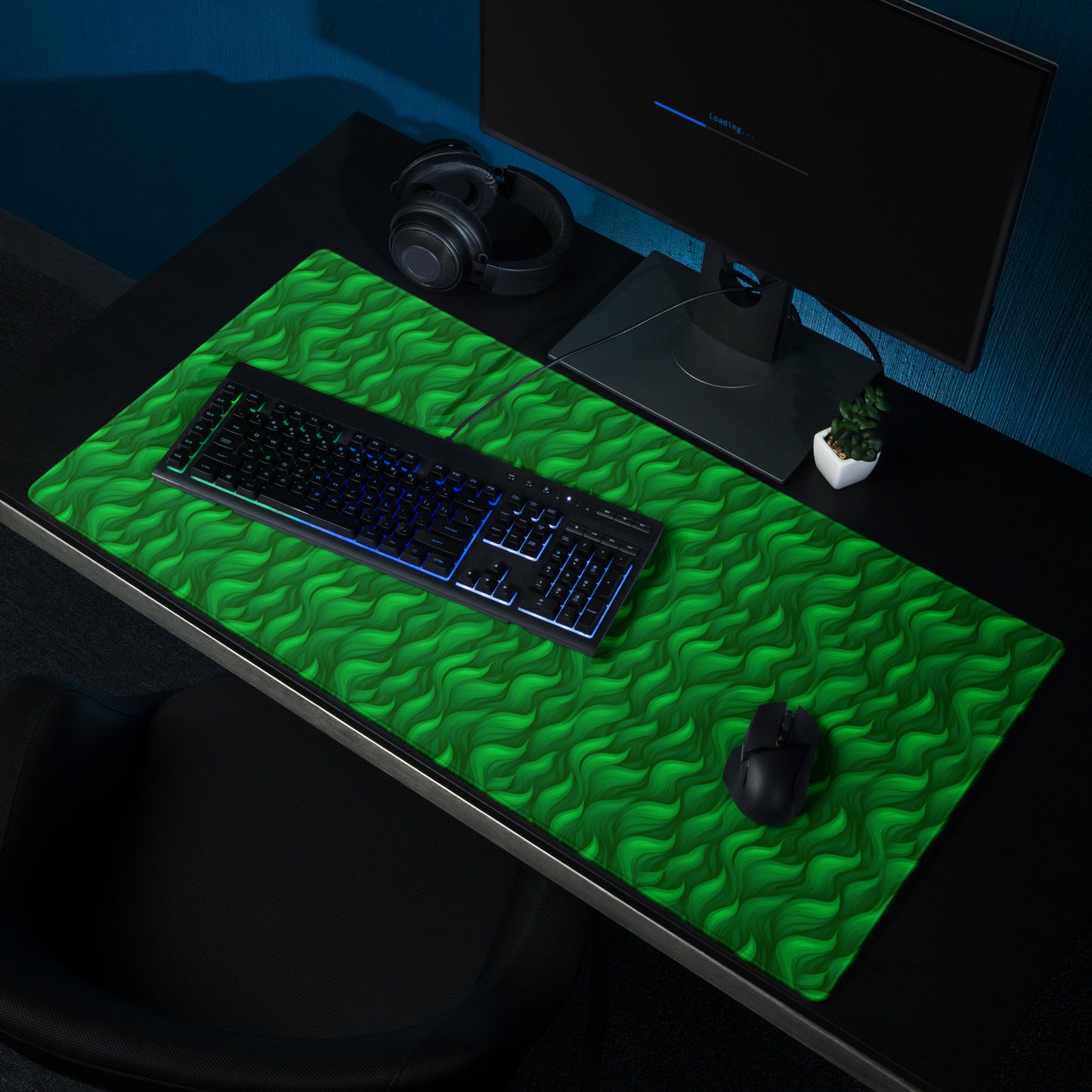 A 36" x 18" desk pad with a wavy flame pattern on it shown on a desk setup. Green in color.