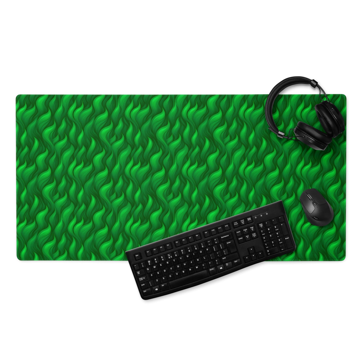 A 36" x 18" desk pad with a wavy flame pattern on it displayed with a keyboard, headphones and a mouse. Green in color.