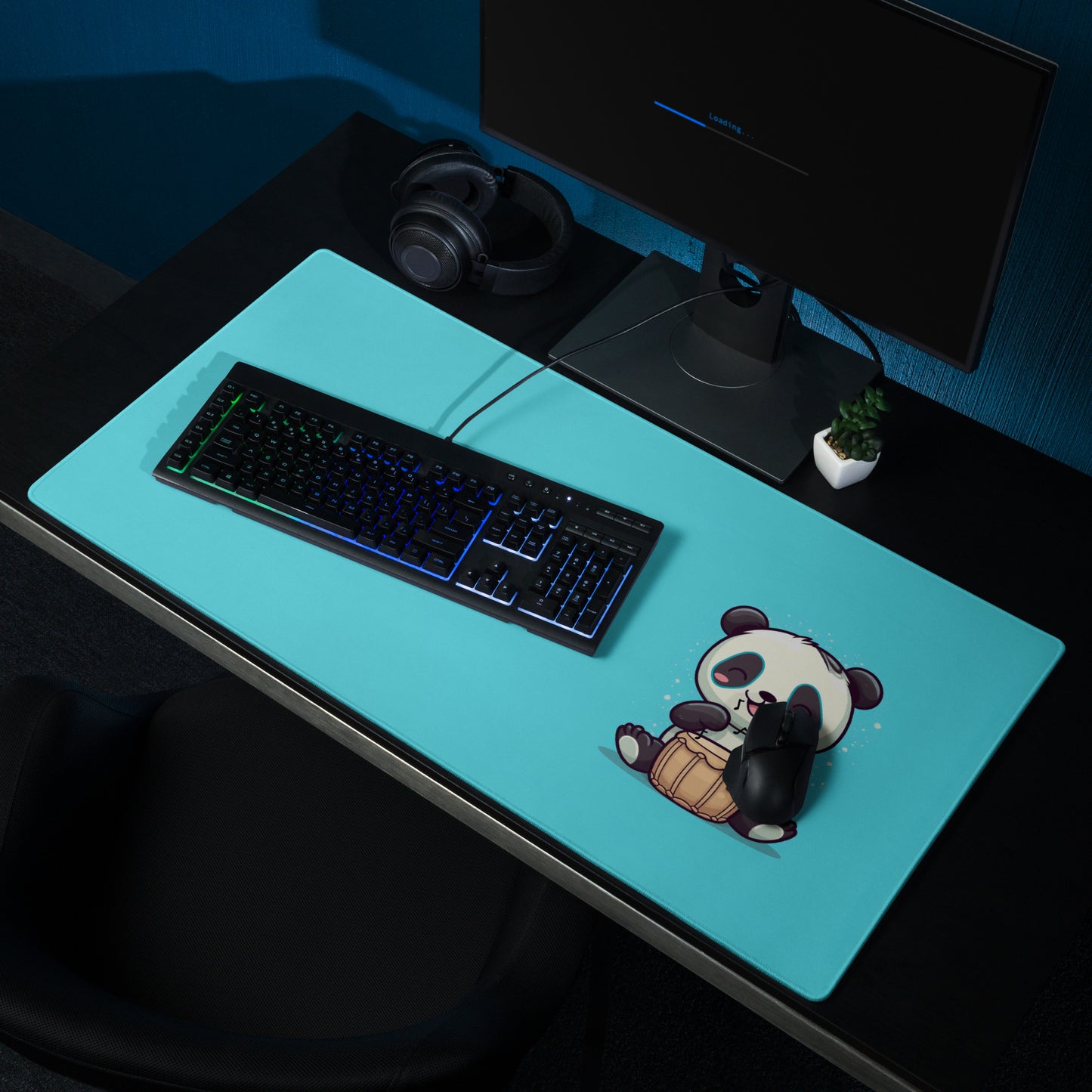 A 36" x 18" desk pad with a cute panda playing the bongos on the right displayed on a desk setup. Blue in color.