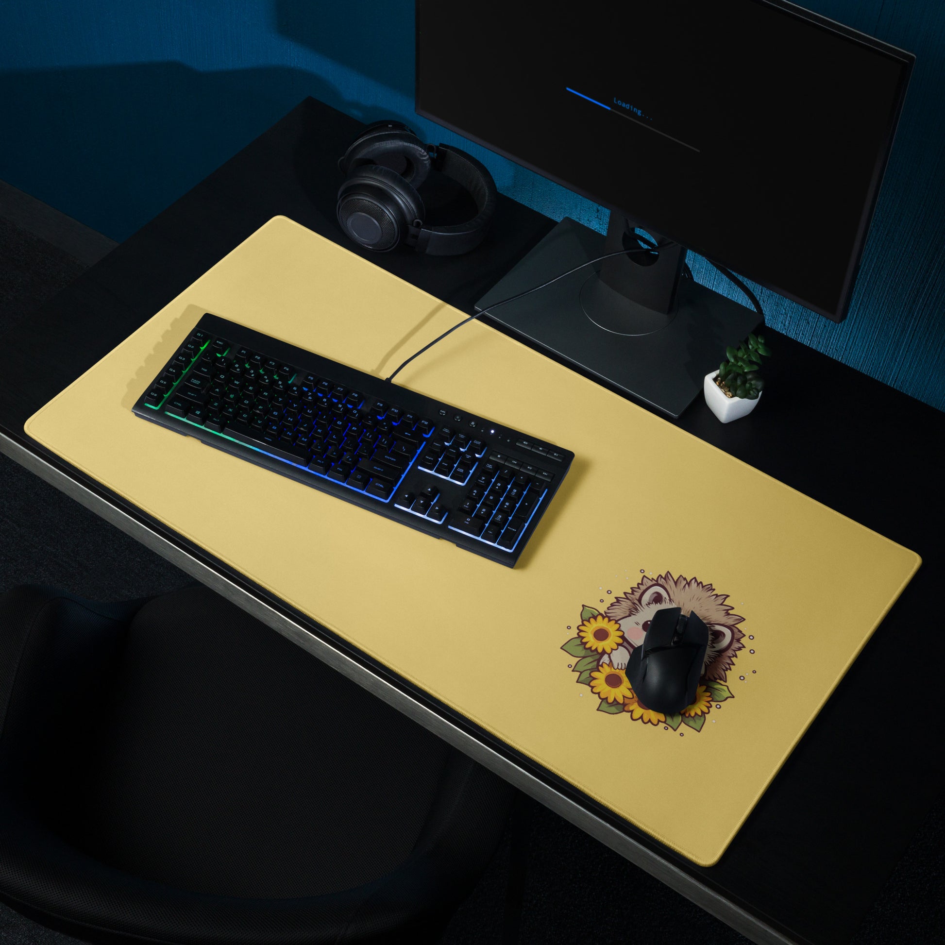 A 36" x 18" desk pad with a cute hedgehog surrounded by sunflowers on it shown on a desk setup. Yellow in color.