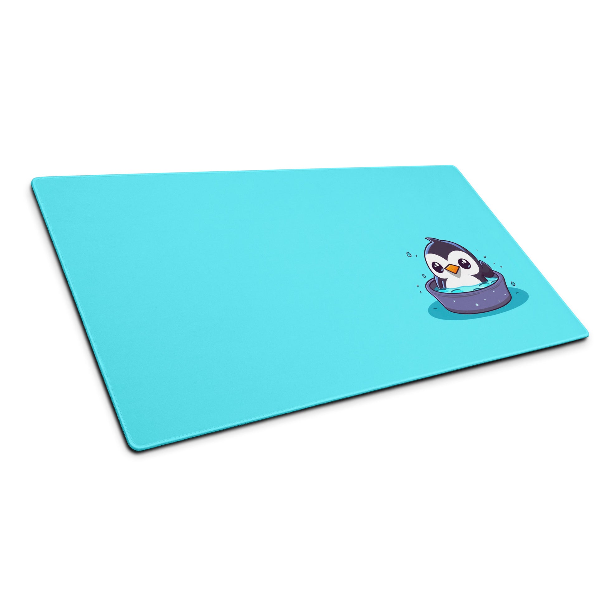 36" x 18" desk pad with a cute penguin sitting in an ice bath on it shown at an angle. Blue in color.