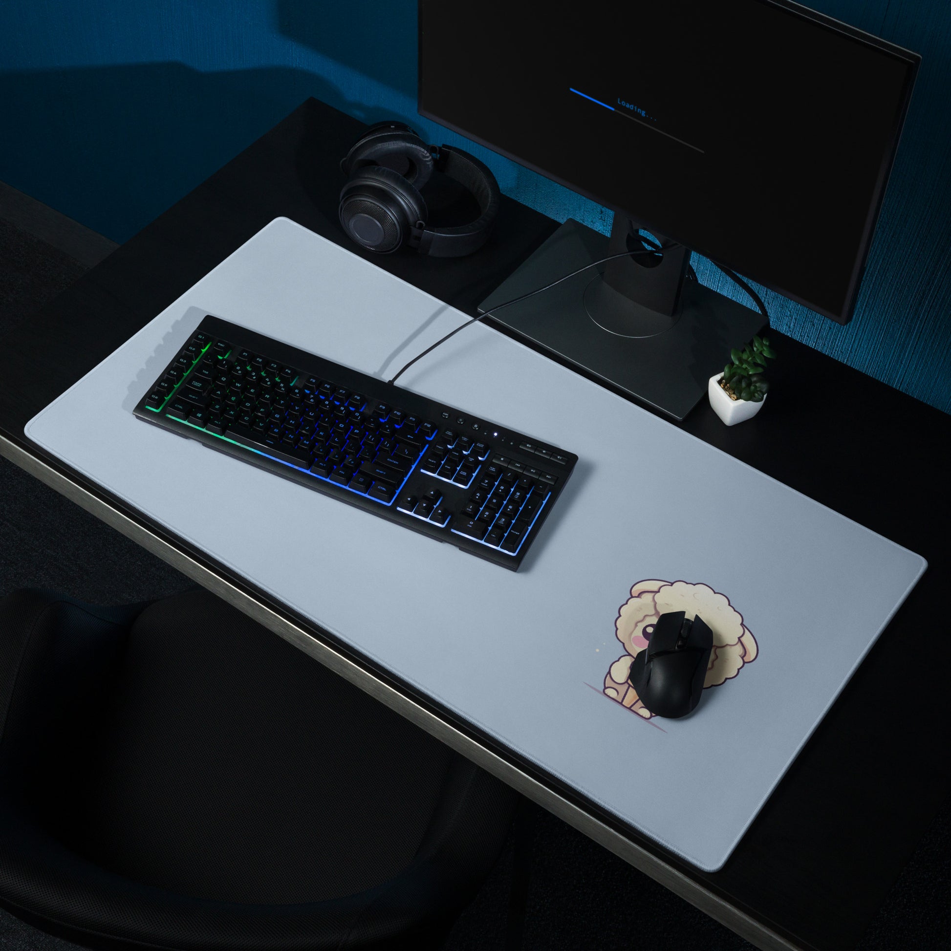 A 36" x 18" desk pad with a cute sheep eating ice cream on it shown on a desk setup. Blue in color.