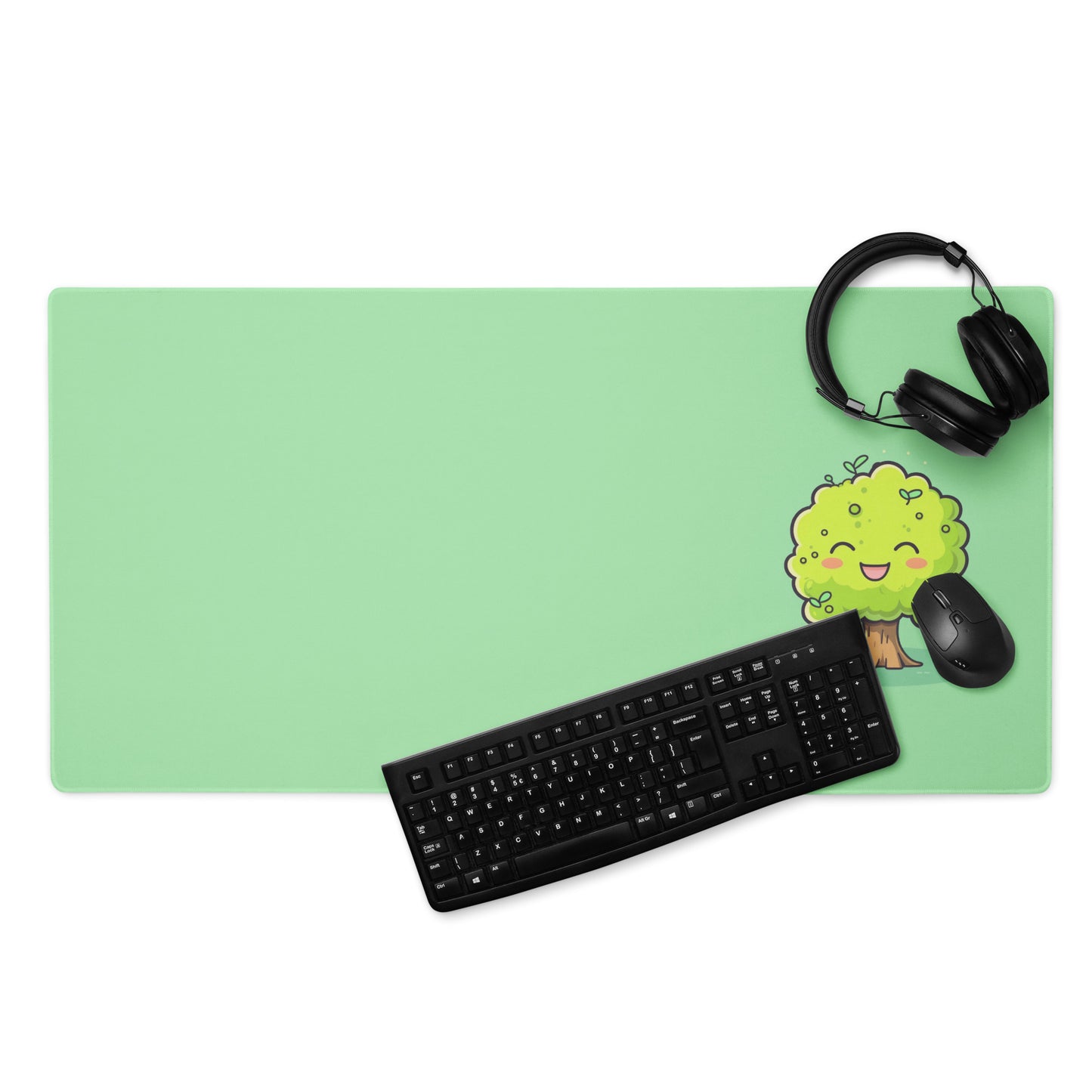 A 36" x 18" desk pad with a cute tree on it displayed with a keyboard, headphones and a mouse. Green in color.