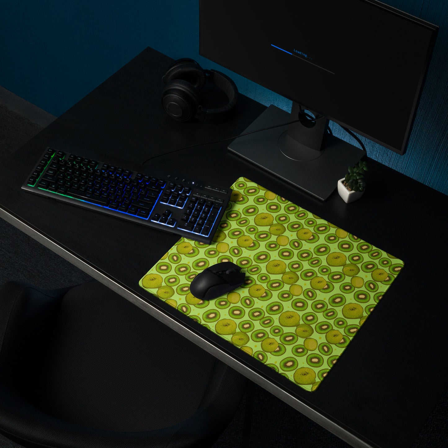 A 18" x 16" desk pad with Kiwis all over it shown on a desk setup. Green in color.