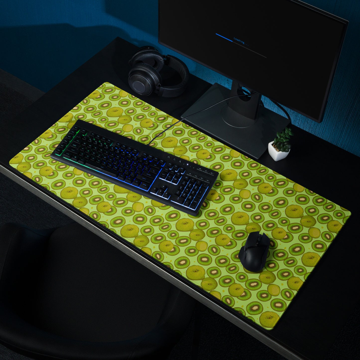A 36" x 18" desk pad with Kiwis all over it shown on a desk setup. Green in color.