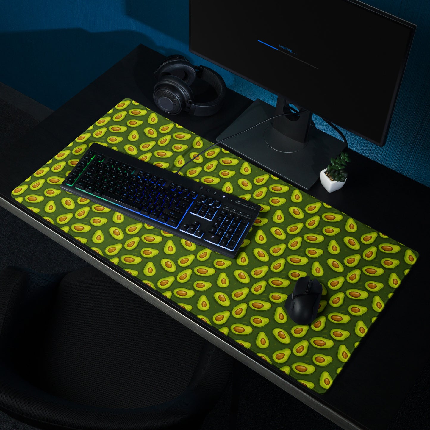 A 36" x 18" desk pad with lots of avocados on it shown on a desk setup. Green in color.