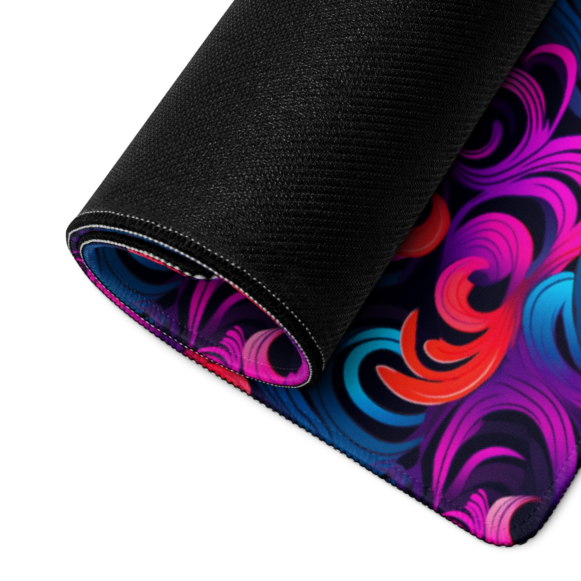 A 36" x 18" desk pad with a bright floral pattern all over it rolled up. Blue, Purple and Red in color.