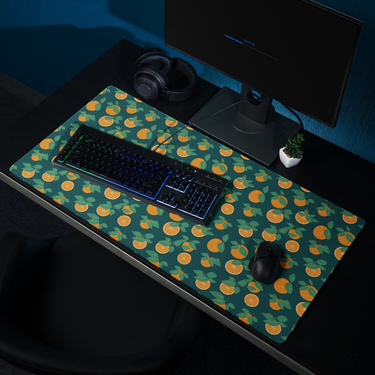 A 36" x 18" desk pad with oranges all over it shown on a desk setup. Orange and Blue in color.