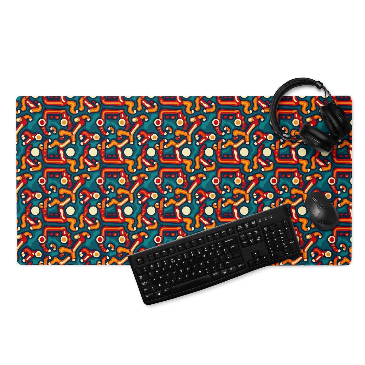 A 36" x 18" desk pad with abstract line art on it displayed with a keyboard, headphones and a mouse. Red, Orange and Teal in color.