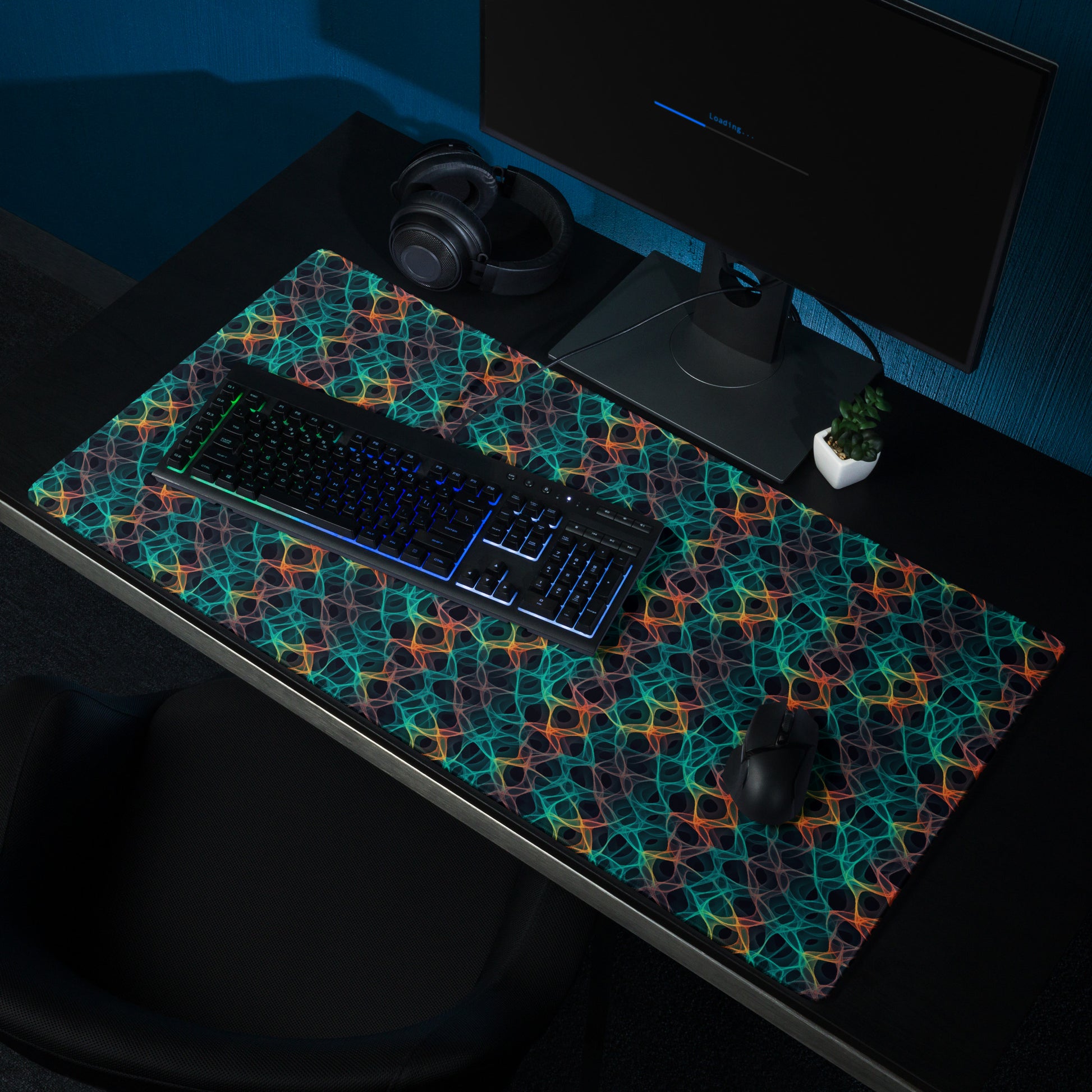 A 36" x 18" desk pad with an abstract pattern resembling a cell structure on it shown on a desk setup. Rainbow in color.