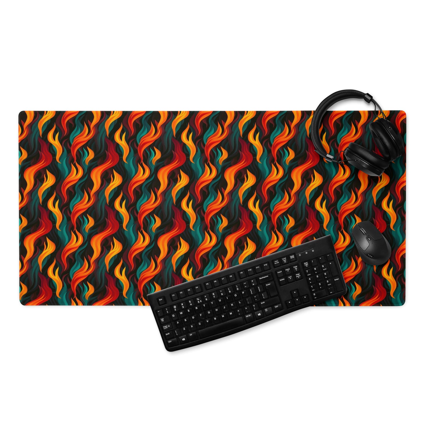 A 36" x 18" desk pad with a wavy flame pattern on it displayed with a keyboard, headphones and a mouse. Red and Teal in color.