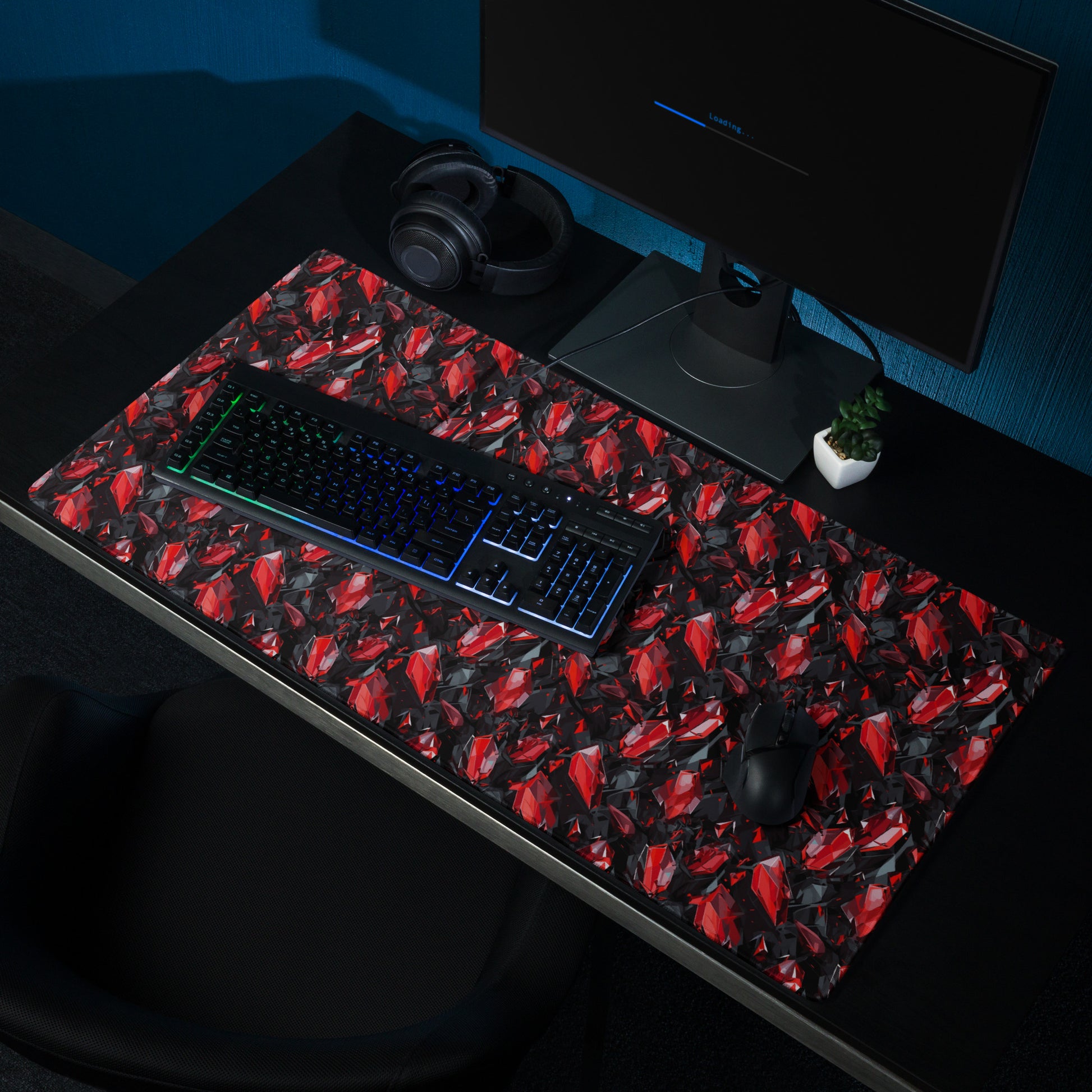 A 36" x 18" gaming desk pad with black and red crystals. It sits on a black desk with a keyboard, monitor, and mouse.
