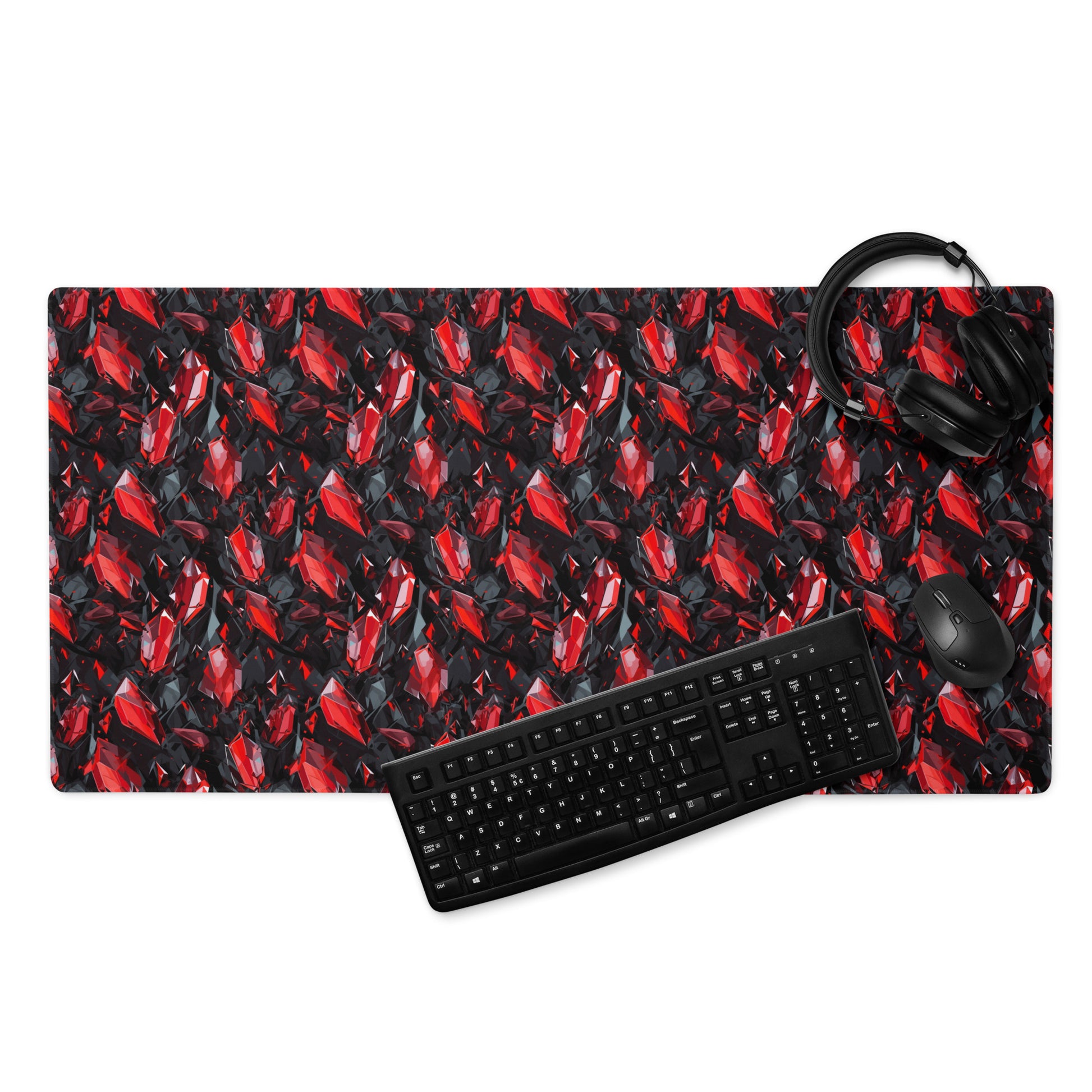 A 36" x 18" gaming desk pad with black and red crystals. A keyboard, mouse, and headphones sit on it.