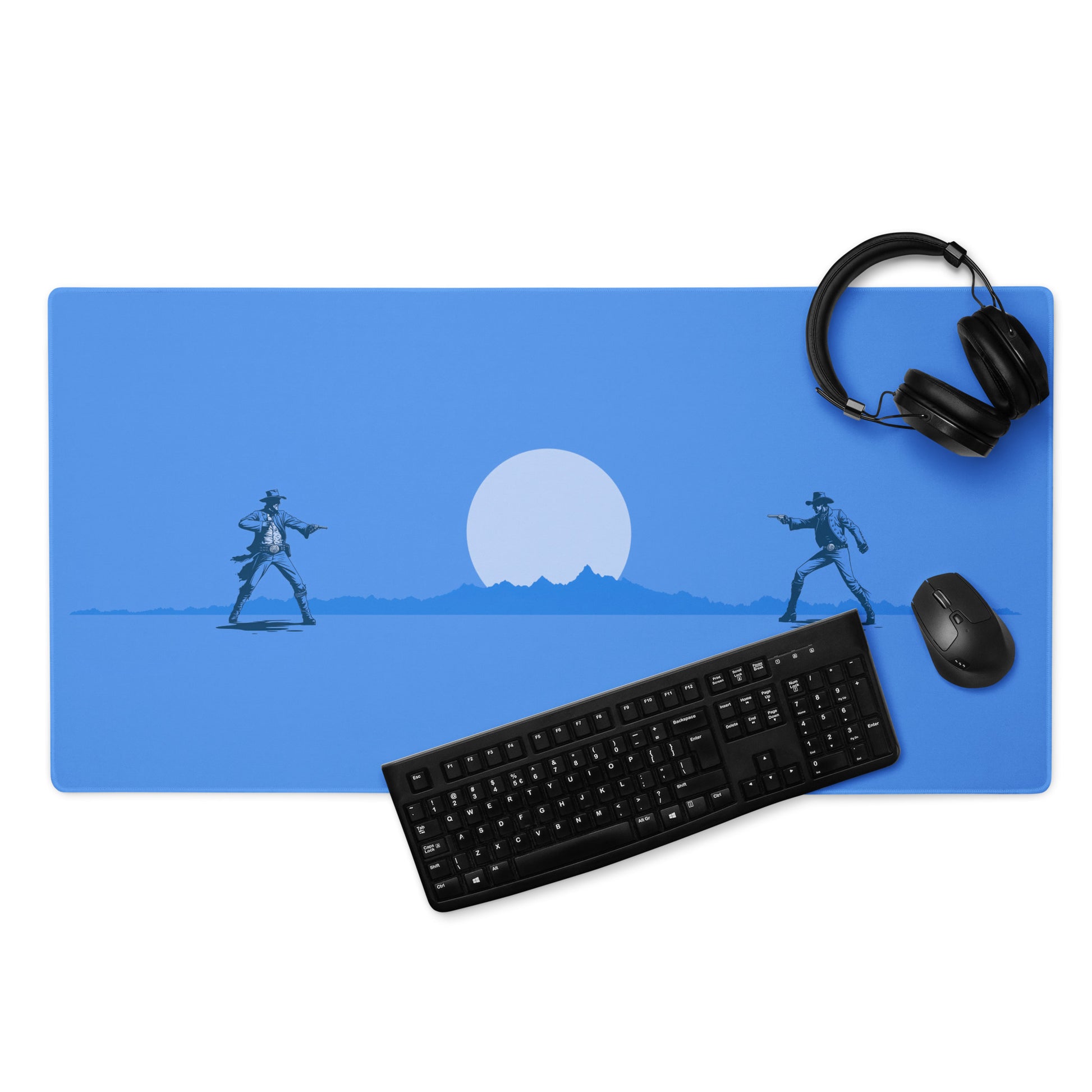 A blue 36" x 18" desk pad with two cowboys dueling. With a keyboard, mouse, and headphones sitting on it.