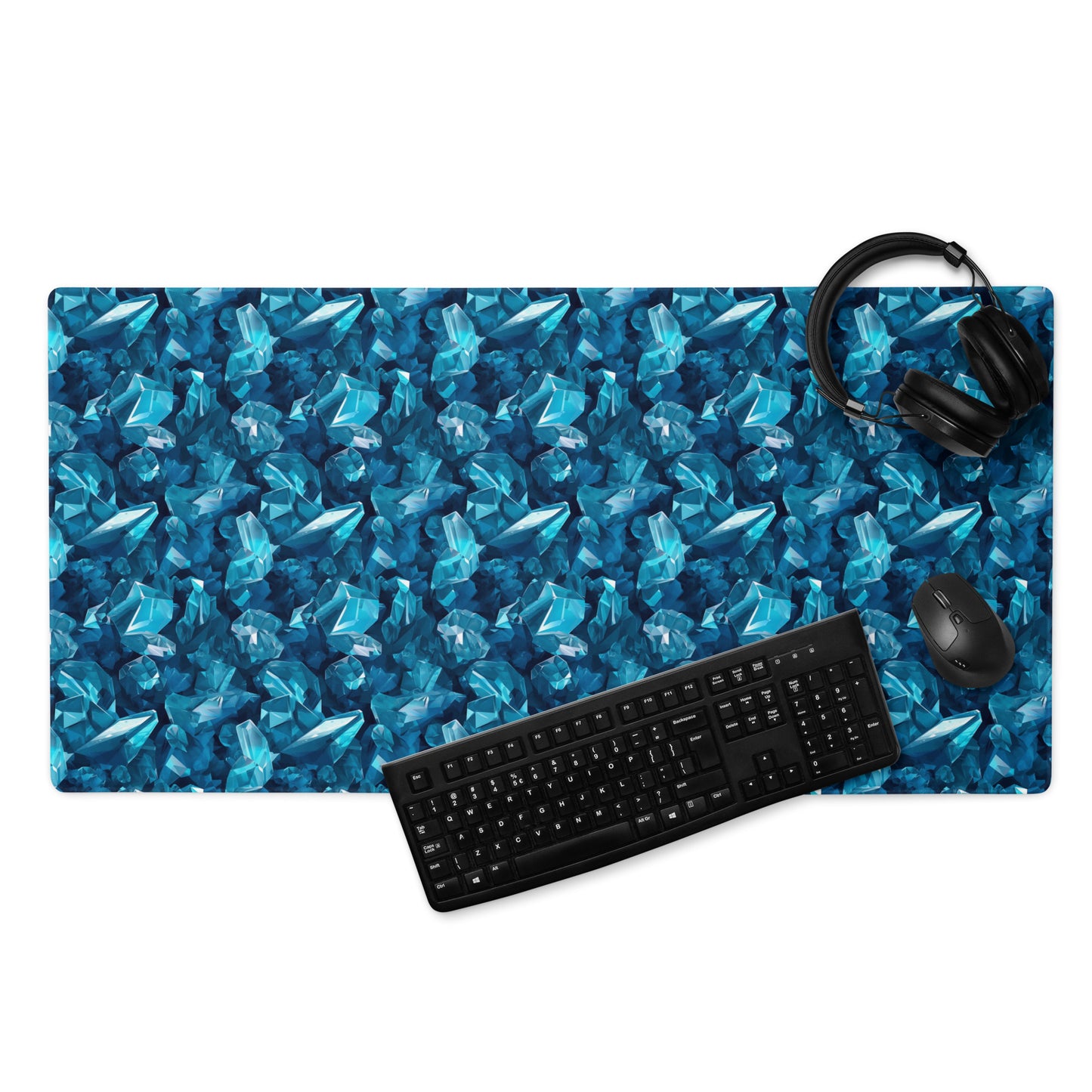 A 36" x 18" gaming desk pad with blue crystals. A keyboard, mouse, and headphones sit on it.