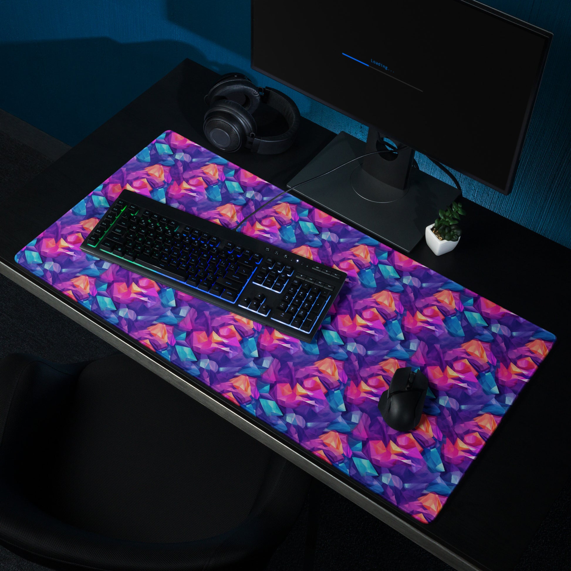 A 36" x 18" gaming desk pad with blue, purple, and orange crystals. A keyboard and mouse sit on it.