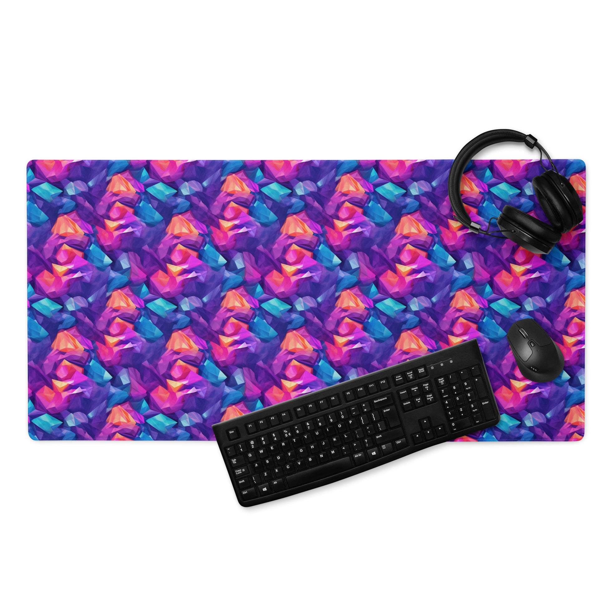 A 36" x 18" gaming desk pad with blue, purple, and orange crystals. A keyboard, mouse, and headphones sit on it.