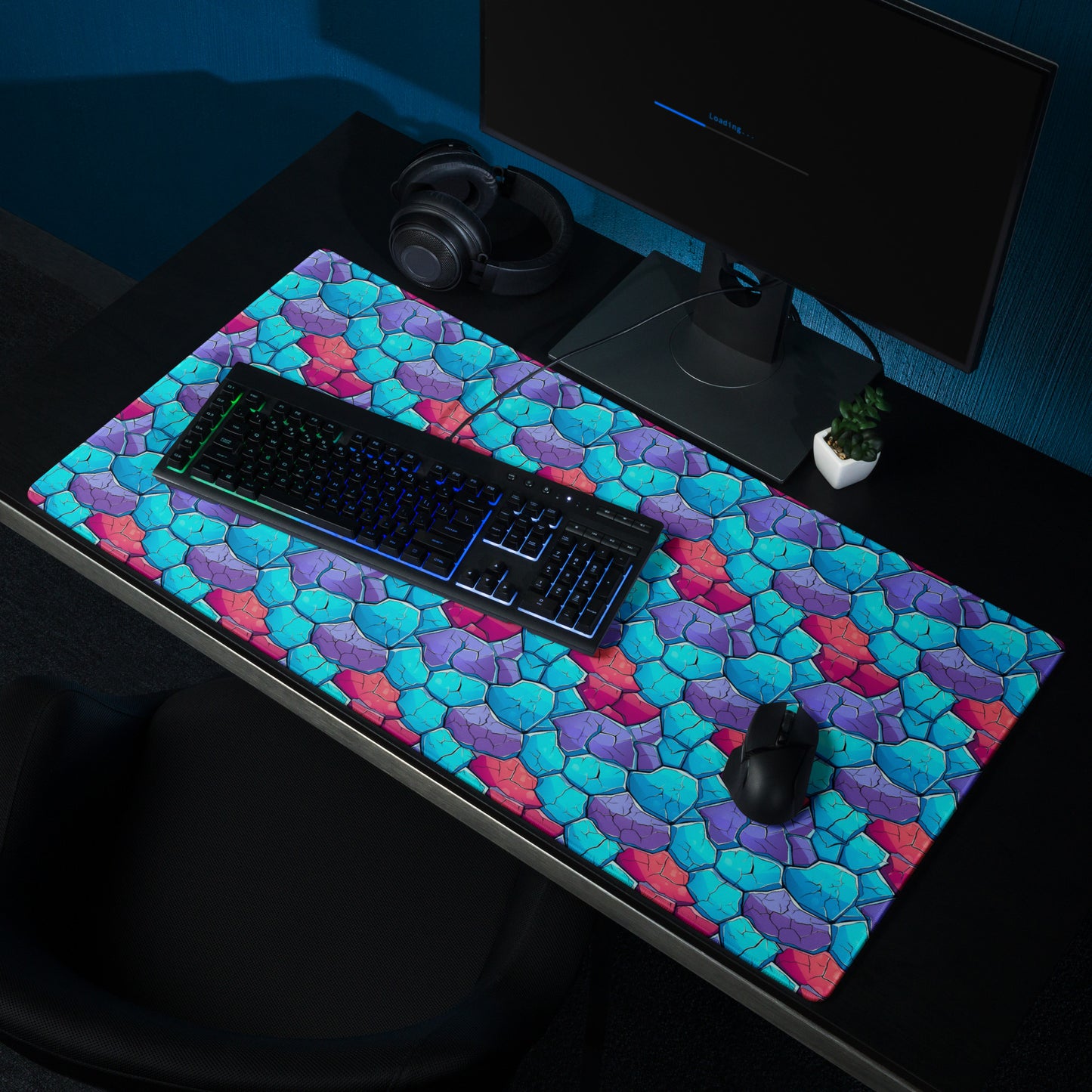 A 36" x 18" gaming desk pad with blue, red, and purple crystals. It sits on a black desk with a keyboard, monitor, and mouse.