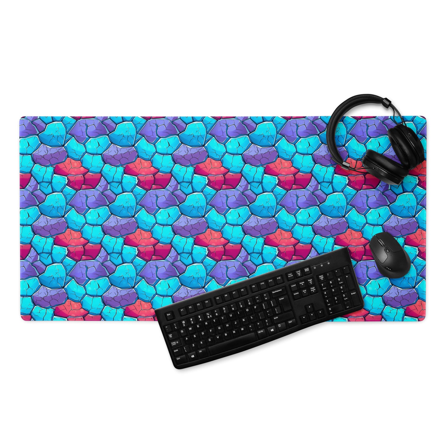 A 36" x 18" gaming desk pad with blue, red, and purple crystals. A keyboard, mouse, and headphones sit on it.