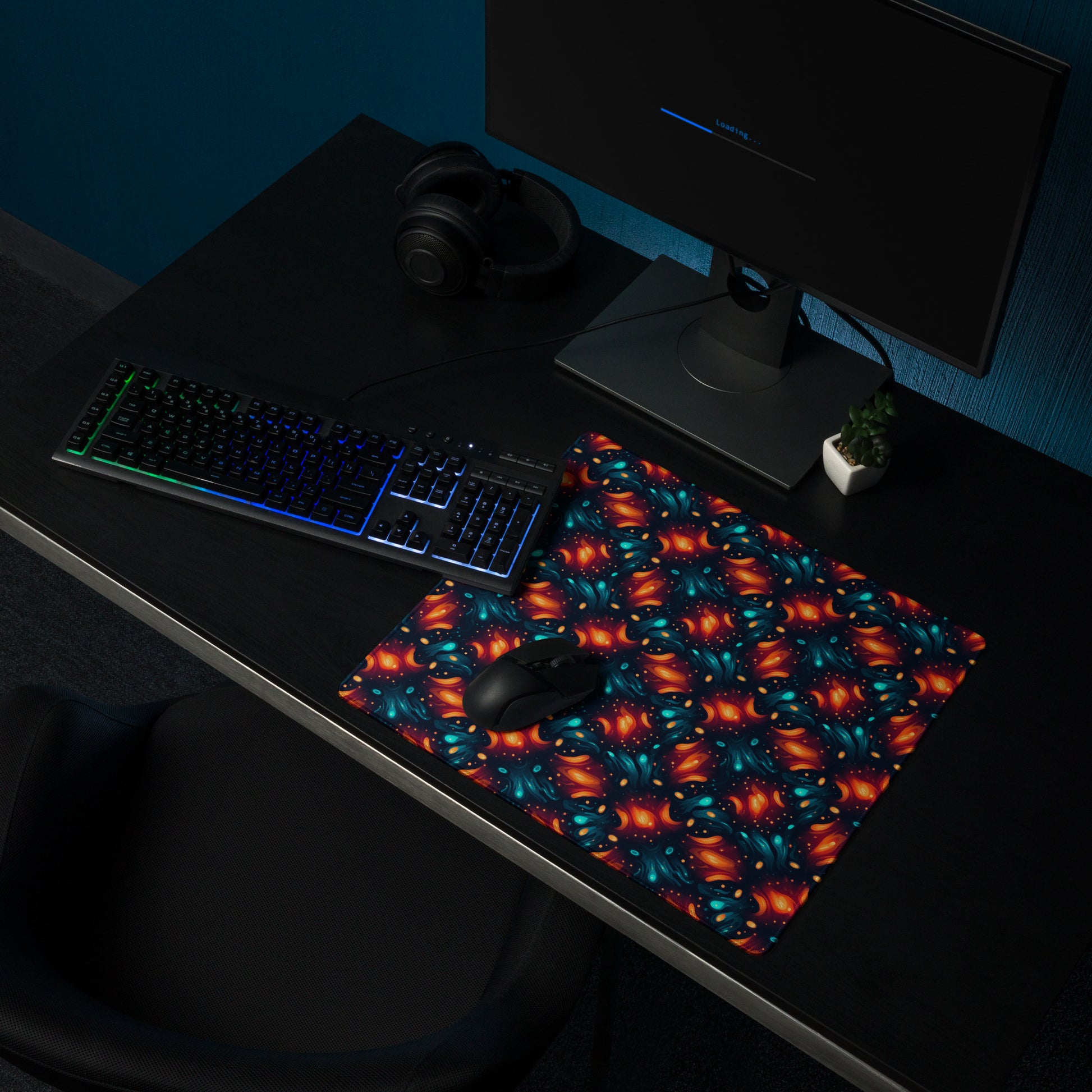 A 18" x 16" desk pad with a blue and orange abstract cross hatch pattern sitting on a desk.