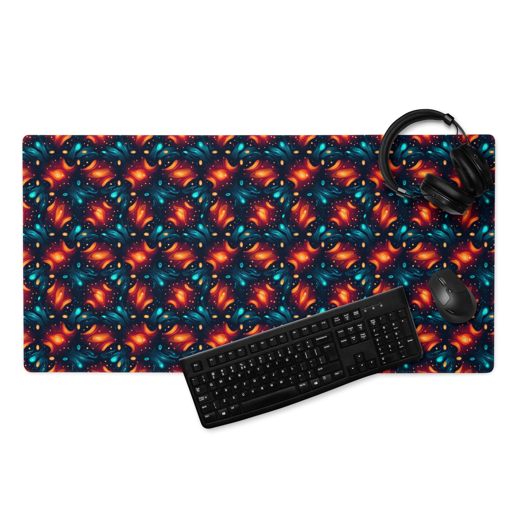 A 36" x 18" desk pad with a blue and orange abstract cross hatch pattern. With a keyboard, mouse, and headphones sitting on it.