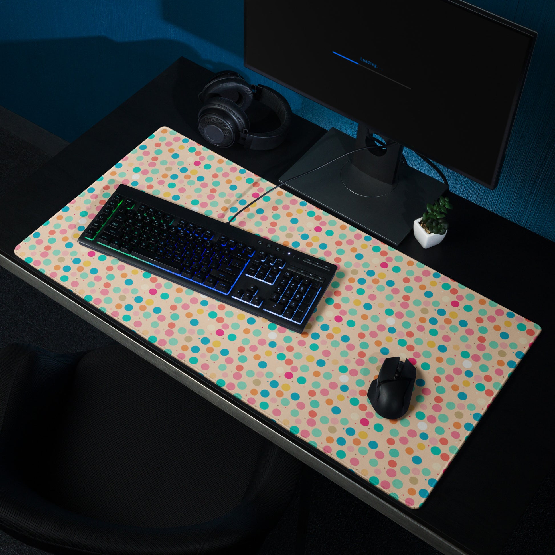 A 36" x 18" desk pad with a colorful polka dot pattern sitting on a desk.