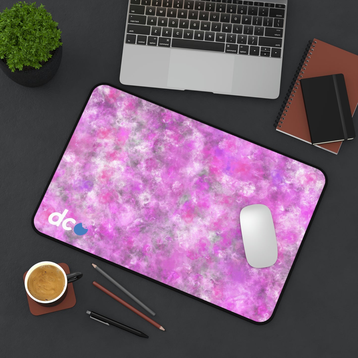 A 12" x 18" desk mat with a fluffy mix of pink, white, and gray sitting at an angle.