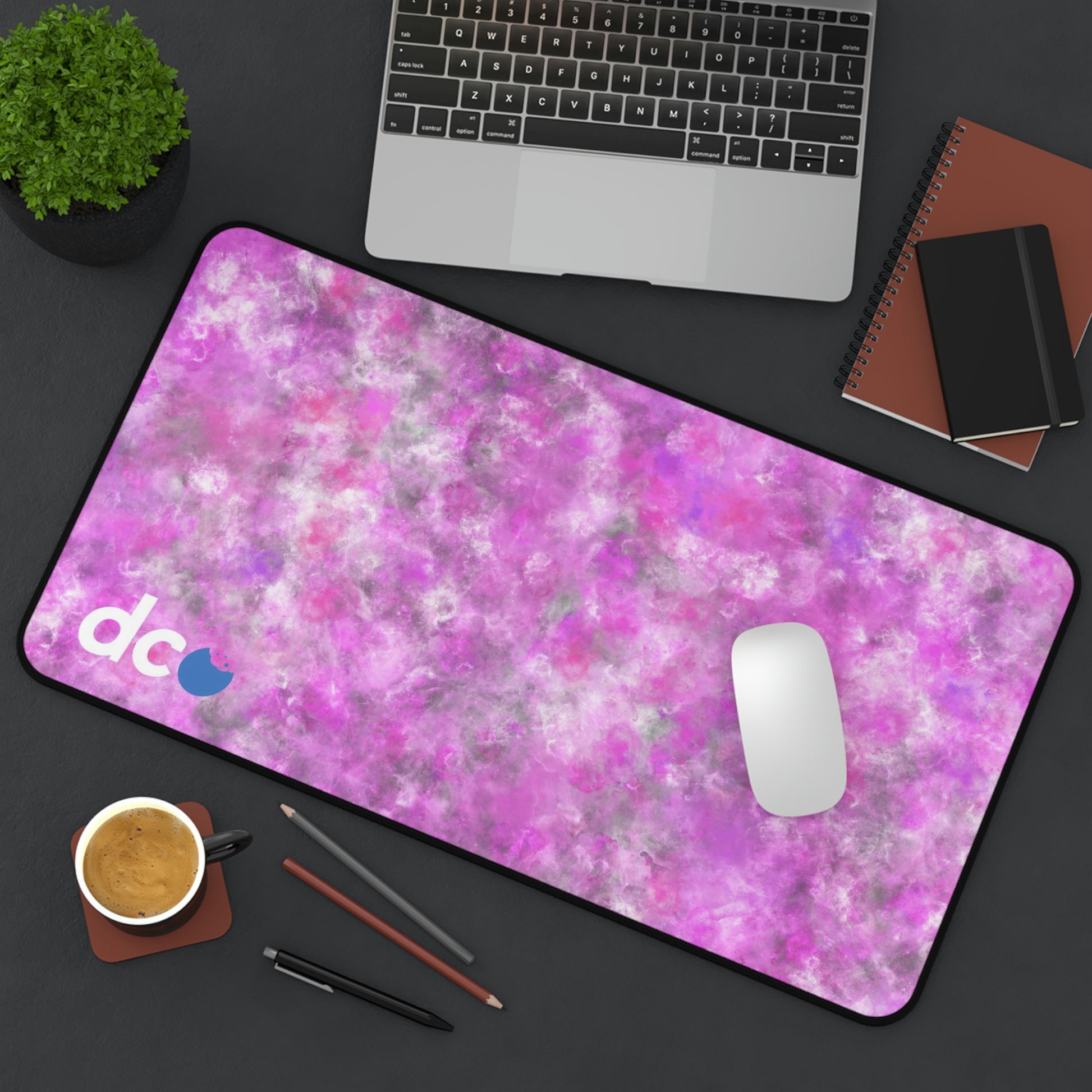 A 12" x 22" desk mat with a fluffy mix of pink, white, and gray sitting at an angle.