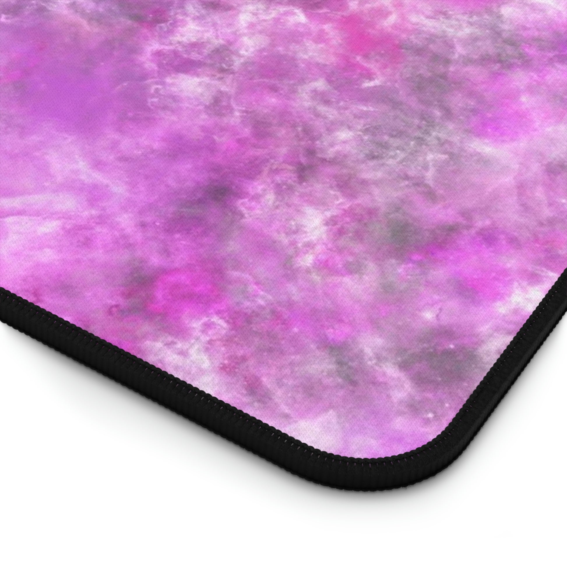 The corner of a 12" x 22" desk mat with a fluffy mix of pink, white, and gray.